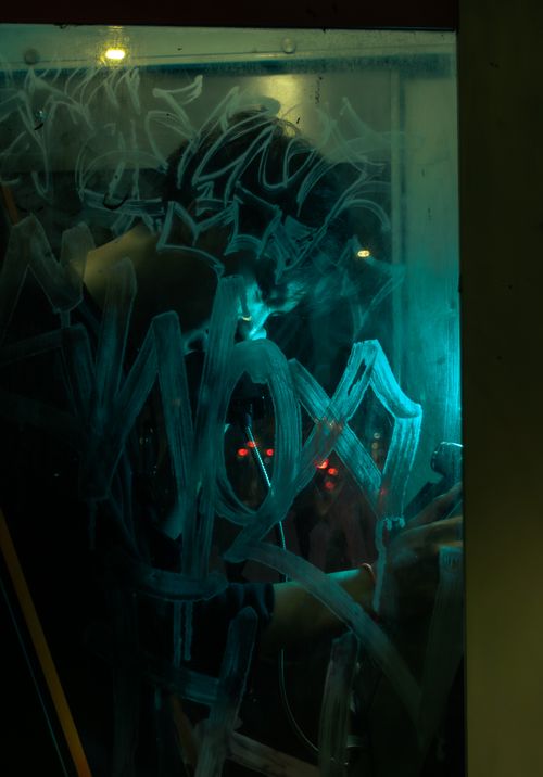 Free A person writes on a foggy window in dim, artistic lighting, creating a mysterious atmosphere. Stock Photo