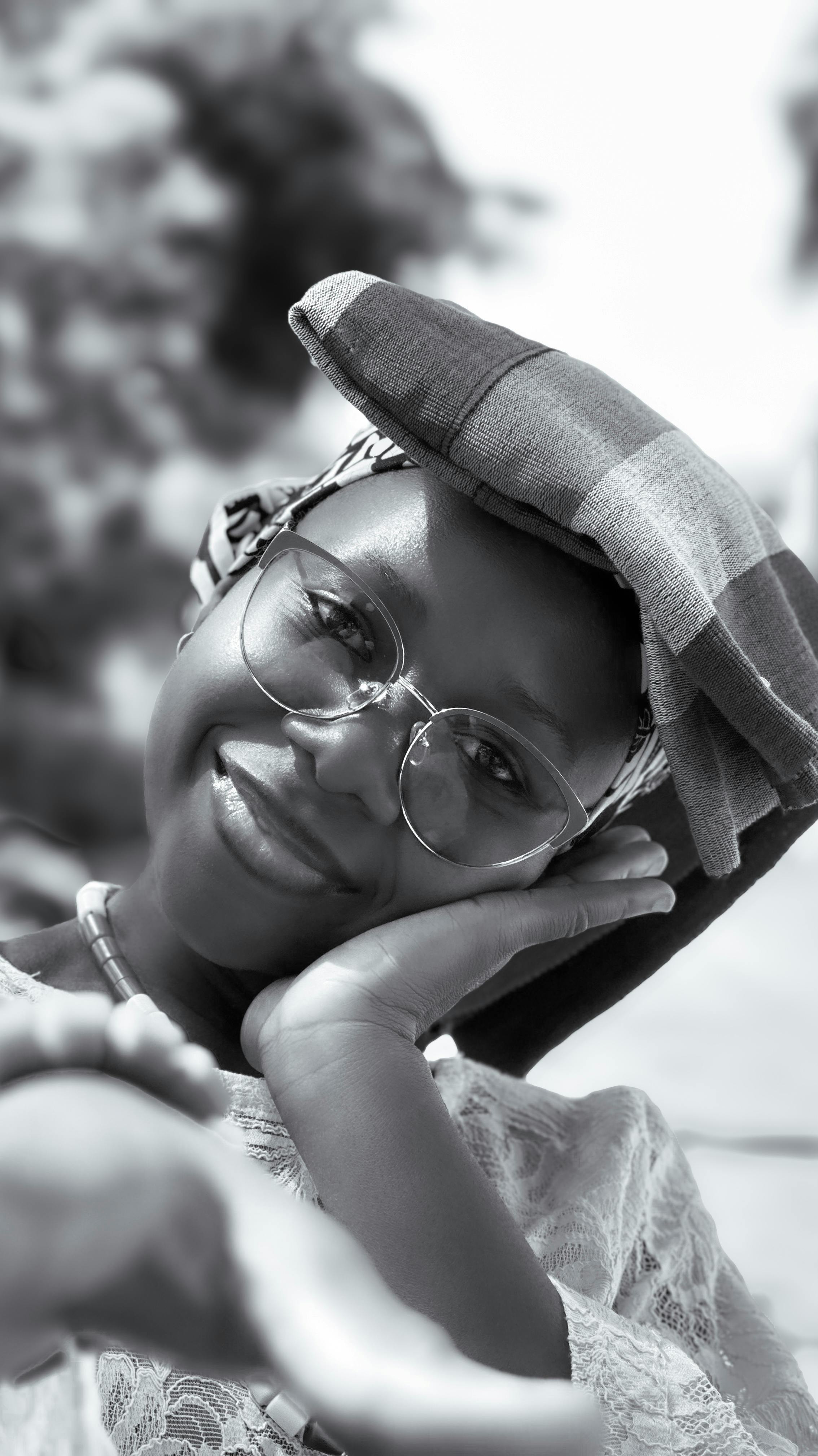 Gratuit O femeie veselă care pozează în haine tradiționale nigeriene în aer liber, surprinsă în monocrom. Fotografie de stoc