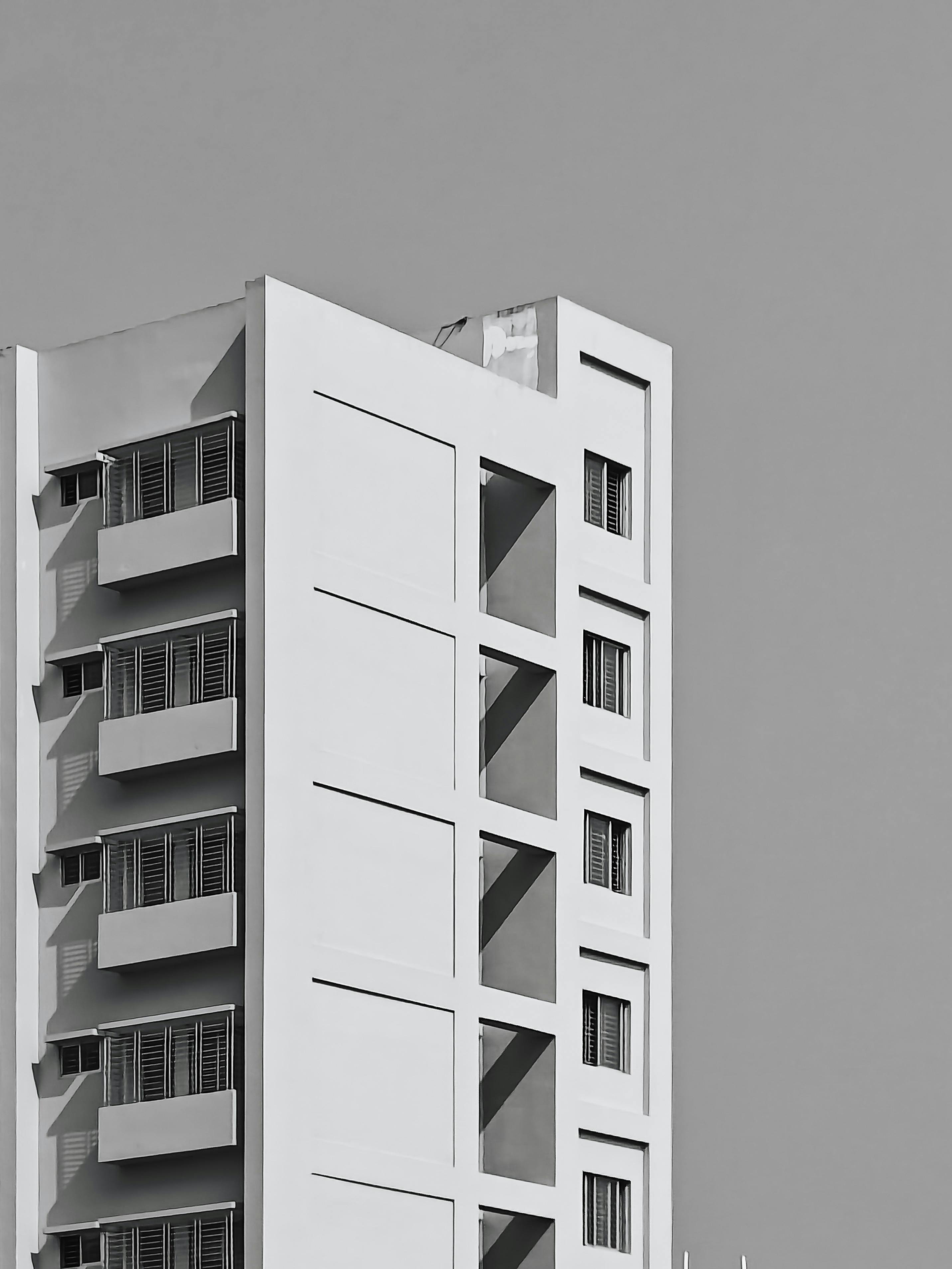 Ücretsiz Modern, minimalist, sade hatlara ve geometrik tasarıma sahip yüksek bir binanın siyah beyaz fotoğrafı. Stok Fotoğraflar