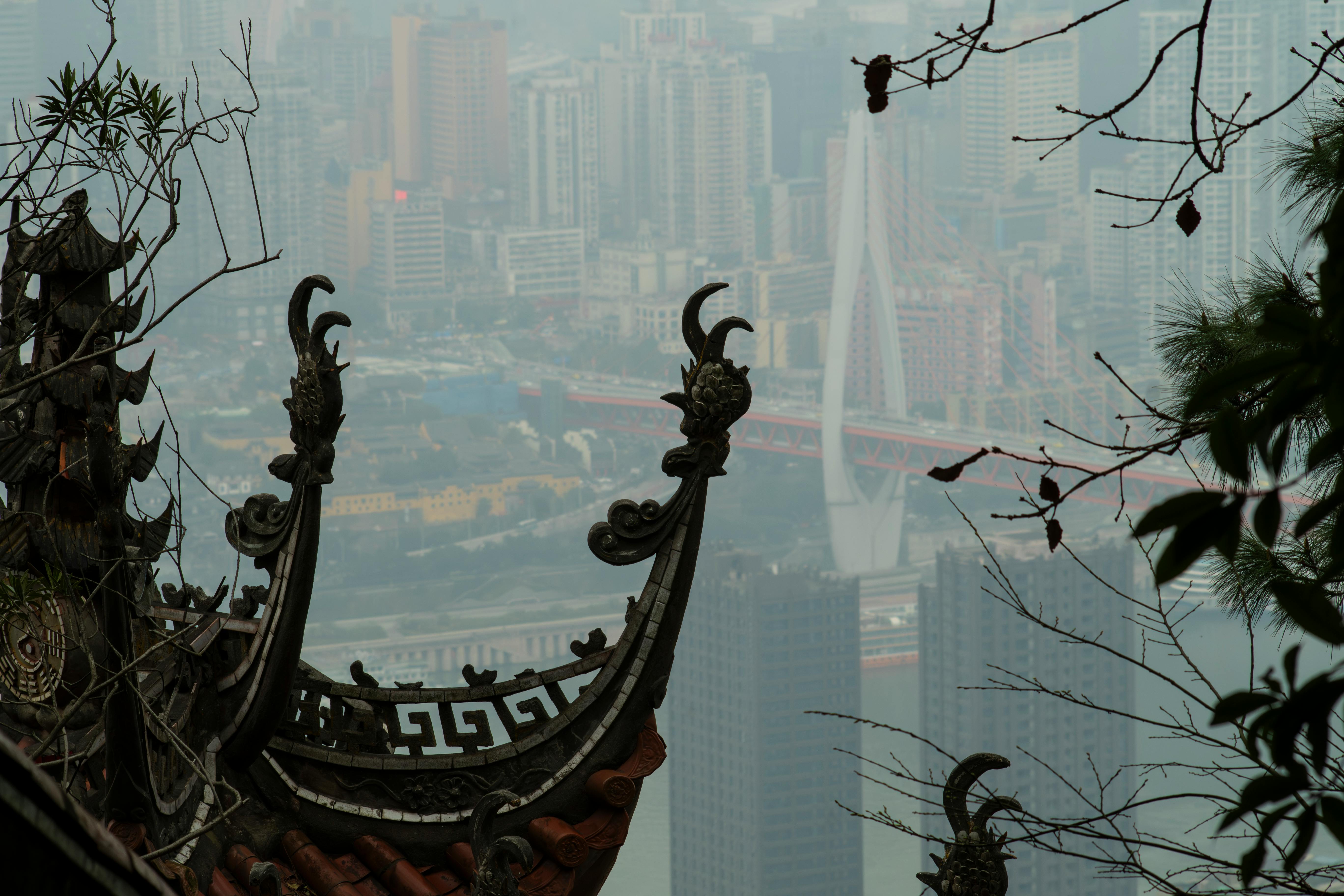 бесплатная Контраст между традиционной азиатской архитектурой и современным городским пейзажем на заднем плане. Стоковое фото