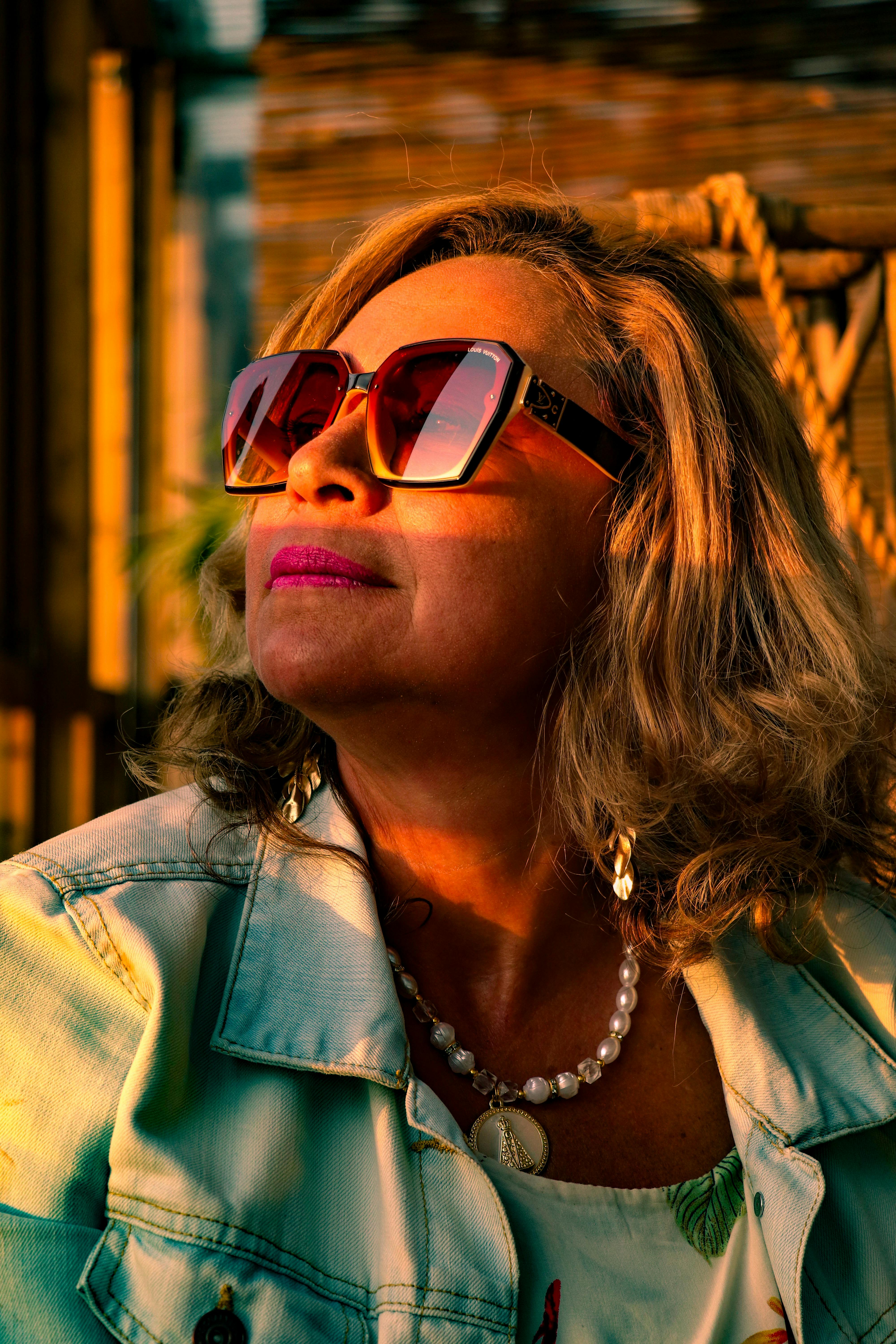 Gratis Eldre kvinne med solbriller nyter en varm solnedgang utendørs i Haag. Arkivbilde