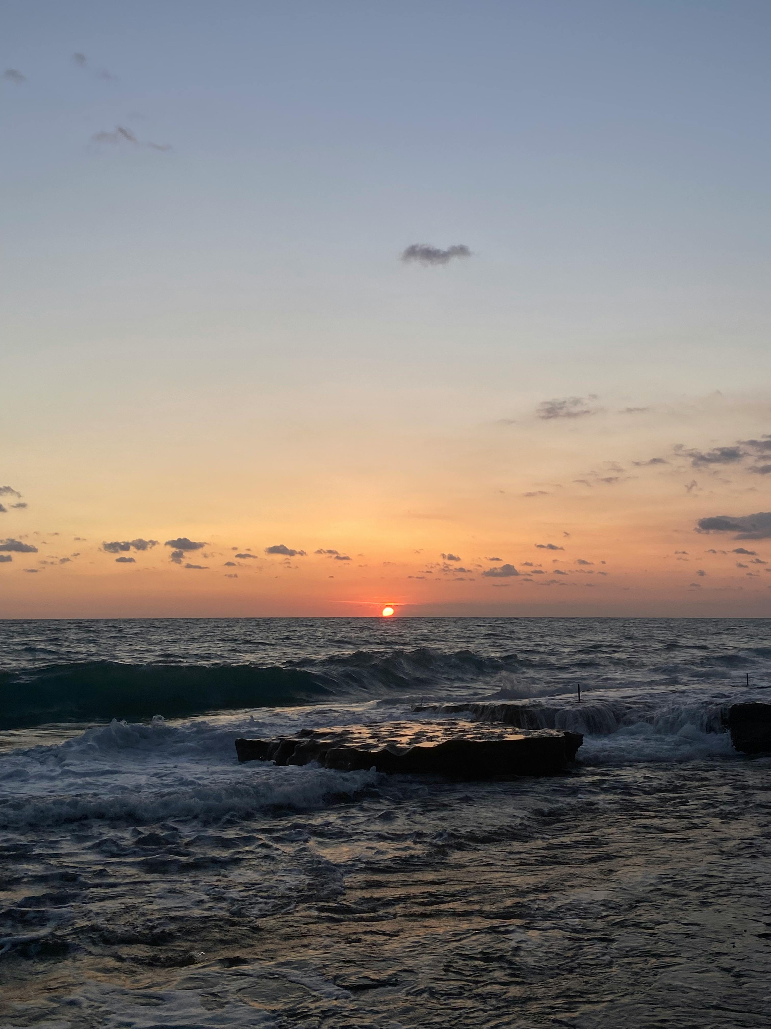 Free Captivating sunset view over the Mediterranean Sea with dramatic waves and a rocky coastline. Stock Photo