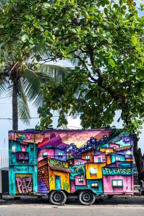 Free Vibrant food truck adorned with Brazilian street art set against palm trees in Rio de Janeiro. Stock Photo