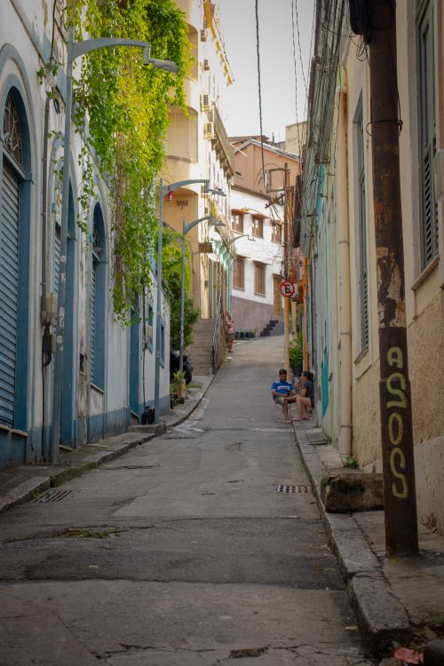 Free Picturesque street view in Santa Teresa, Rio with colorful buildings, greenery, and locals. Stock Photo