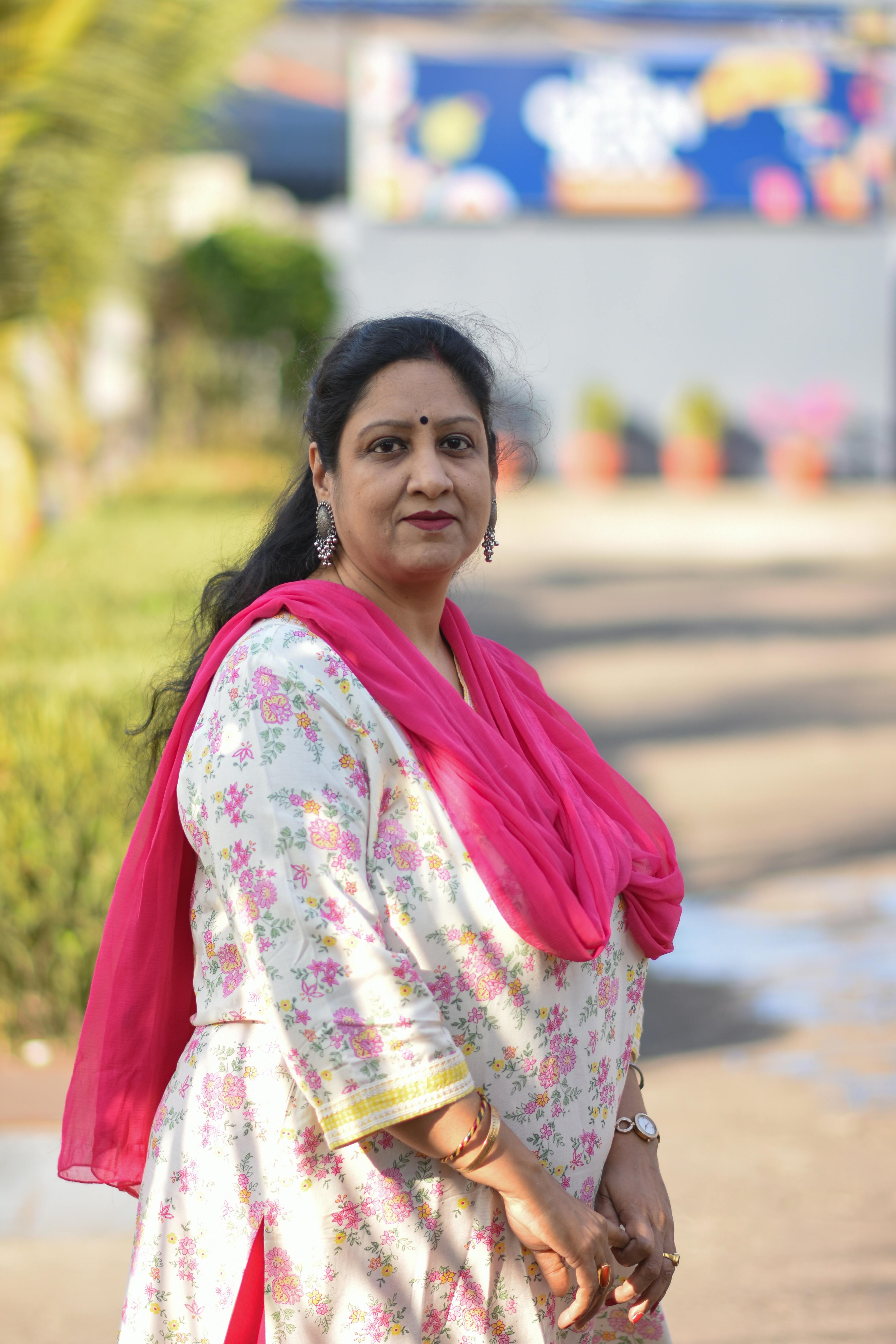 South Asian woman in floral traditional attire standing outdoors in Gobindpur, India.