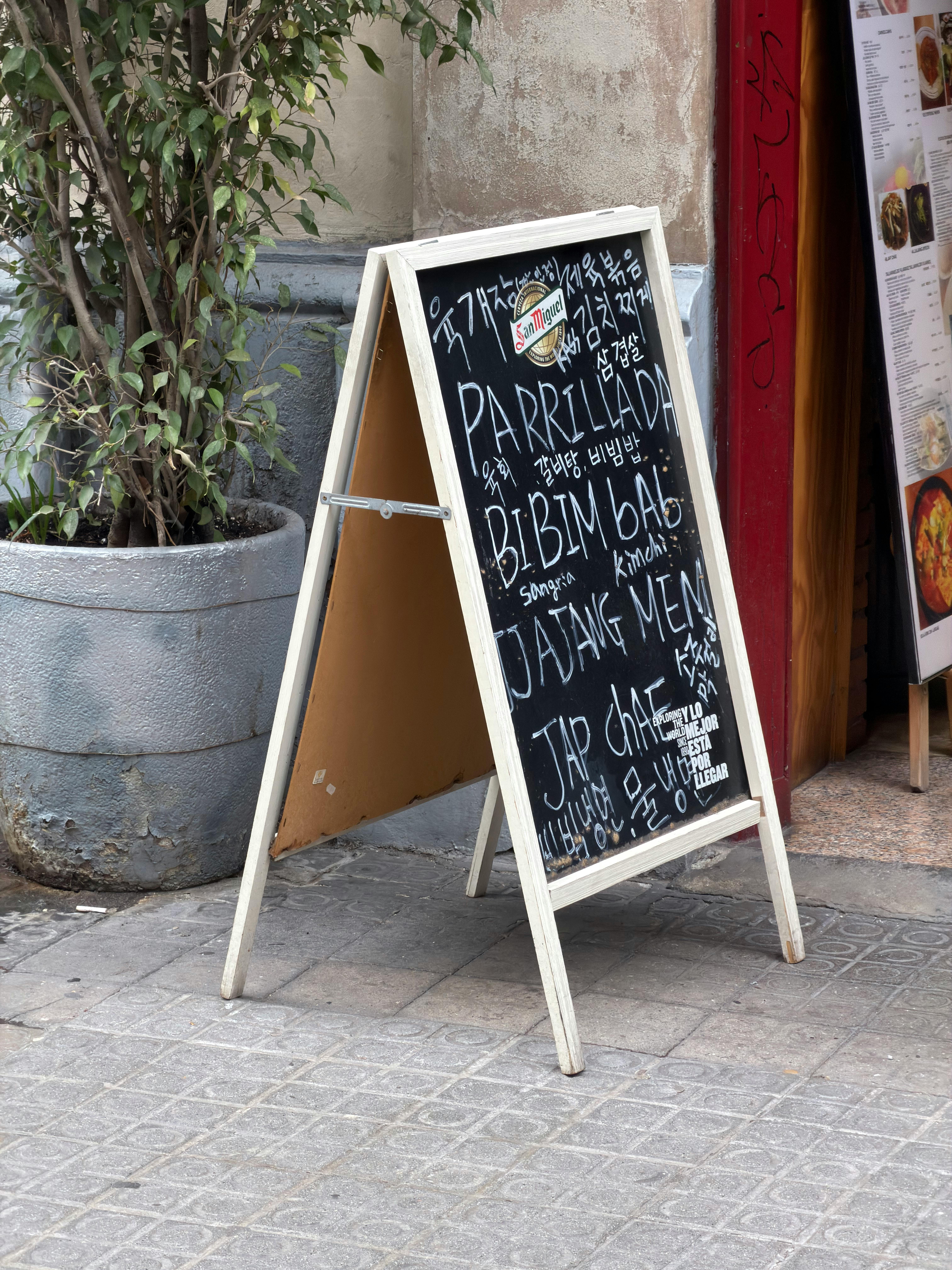 無料 スペイン、バルセロナの路上に掲げられた、各国料理が書かれた黒板メニュー。 写真素材