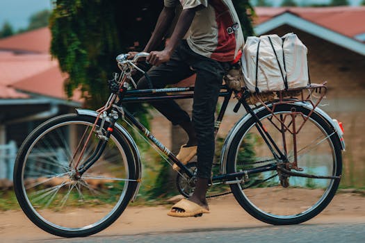A person riding a bicycle with packages outdoors on a sunny day.