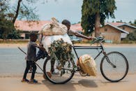 Father and son transporting goods by bicycle