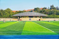 Vibrant Green Athletic Field with Relaxing Students