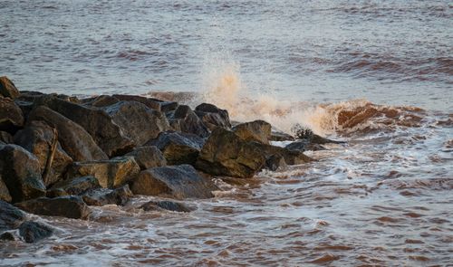 Free Dynamic capture of ocean waves crashing on rugged rocks, showcasing nature's power. Stock Photo