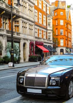 Luxury car parked on a stylish historic street in London, showcasing classic architecture.