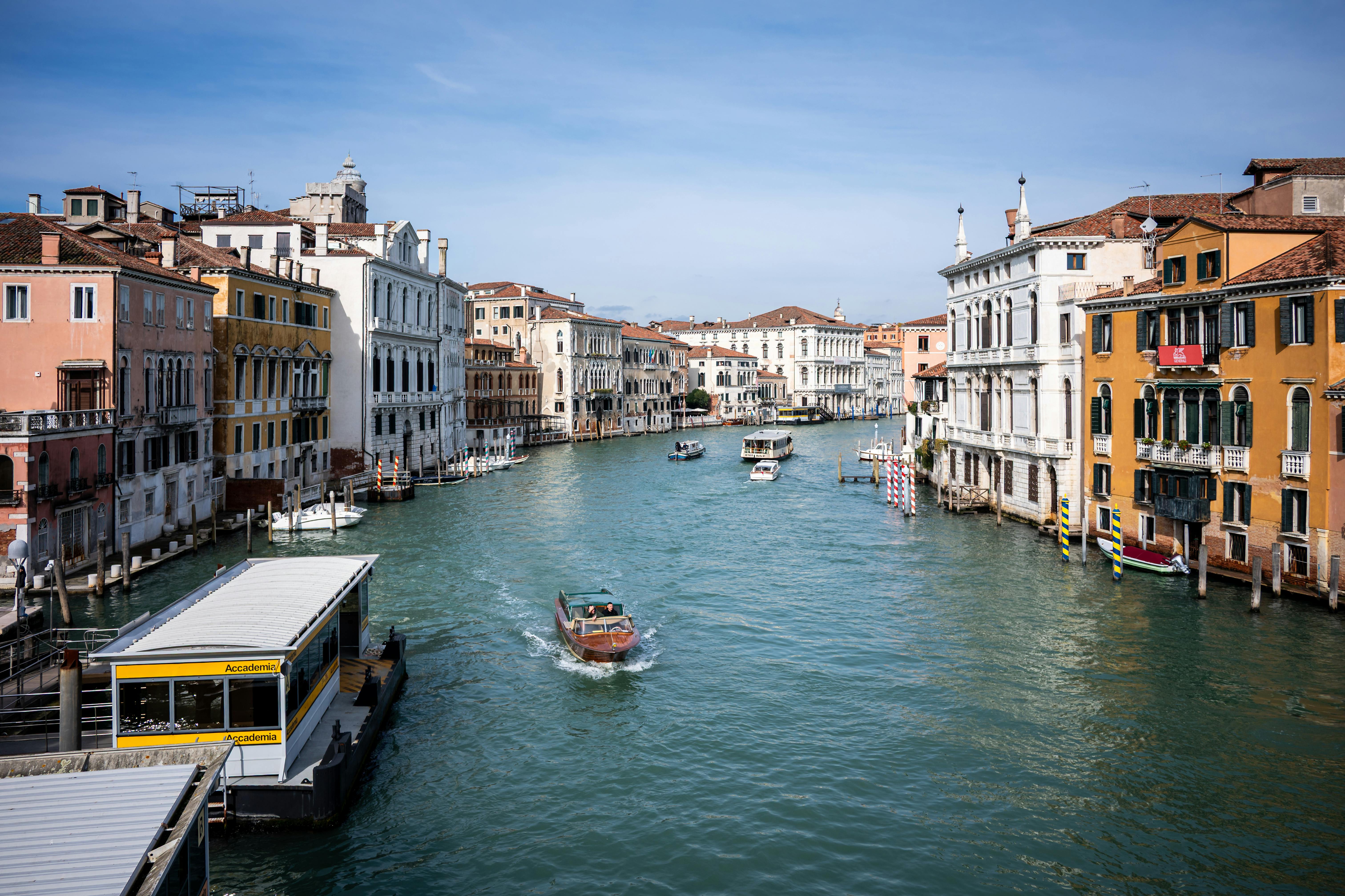 無料 色鮮やかな建築物と水路が織りなすヴェネツィアの活気ある運河風景 写真素材