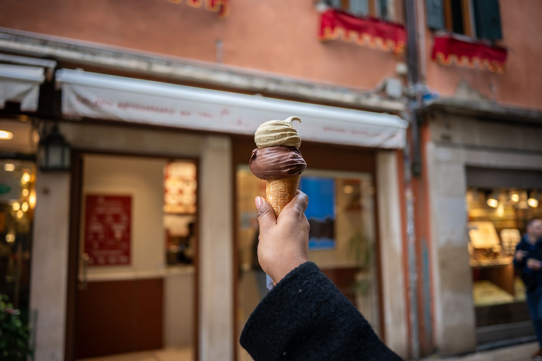 Un cono di gelato tenuto in mano per strada