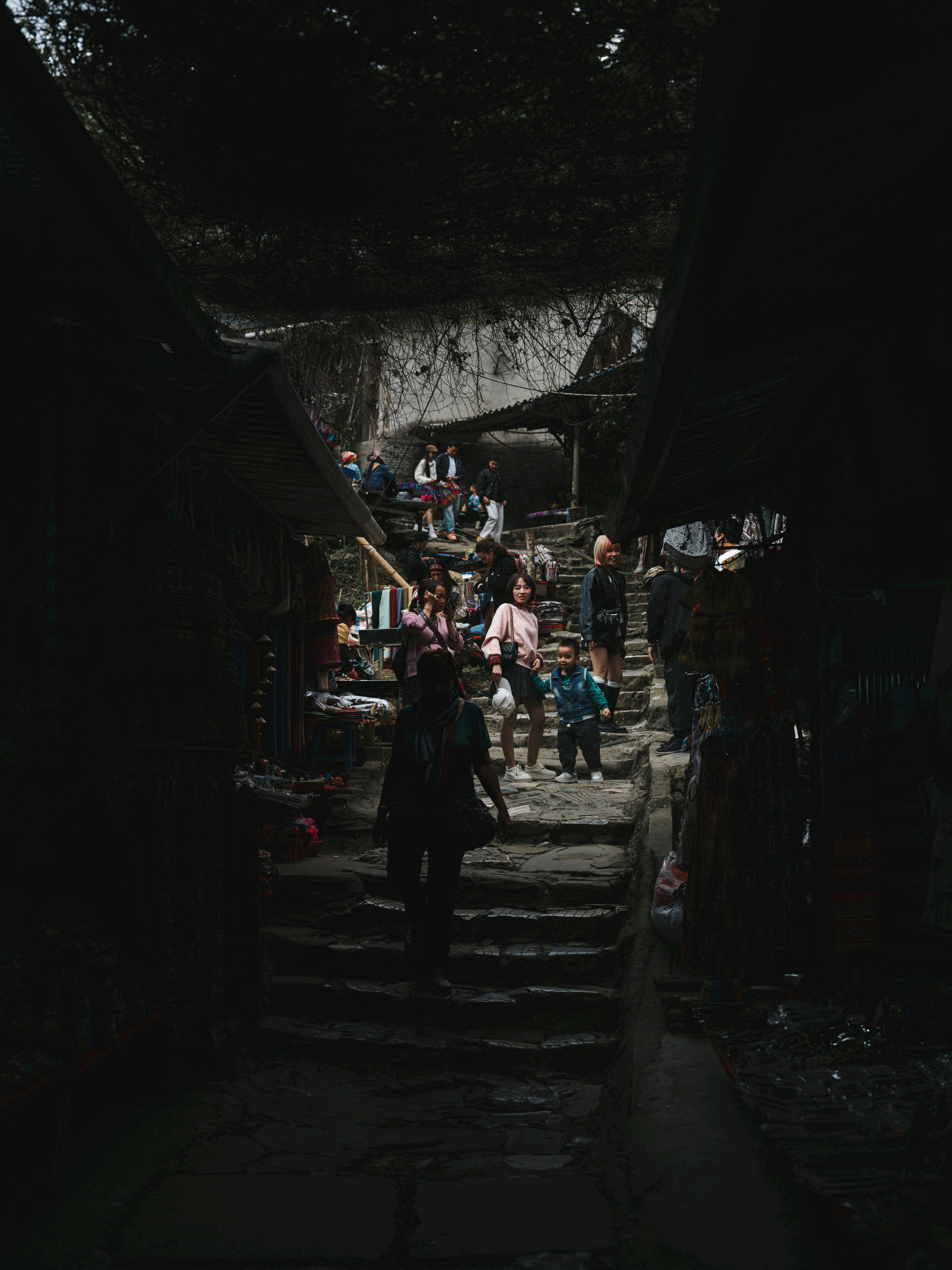 бесплатная Люди прогуливаются по оживленному рынку в городе Лаокай, Вьетнам, демонстрируя яркую местную культуру. Стоковое фото