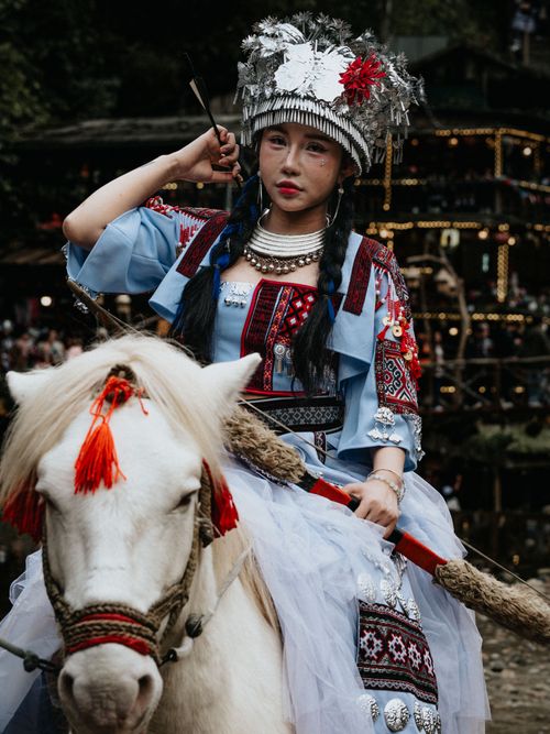 Free A woman in traditional Hmong attire riding a decorated horse in Lào Cai, Vietnam. Stock Photo