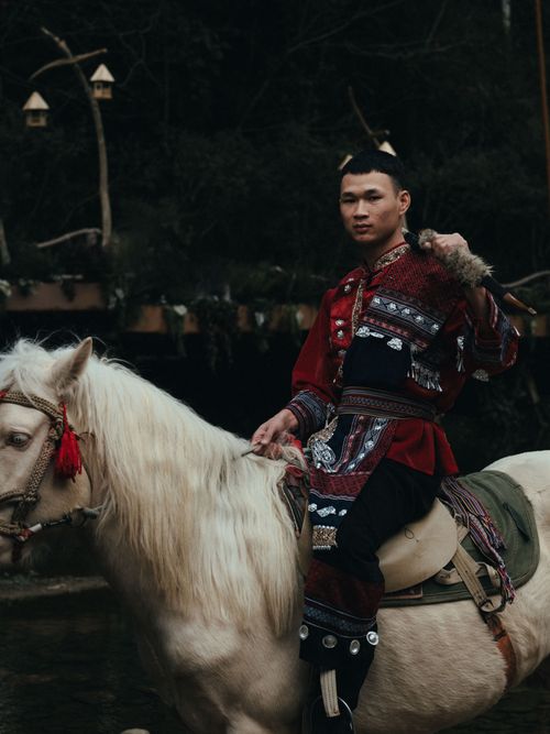 Free A Hmong man rides a white horse in traditional attire in Lào Cai, Vietnam, capturing cultural heritage. Stock Photo