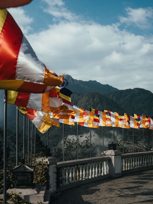 Free Vibrant Buddhist flags waving in the mountain breeze of Lào Cai, Vietnam. Stock Photo