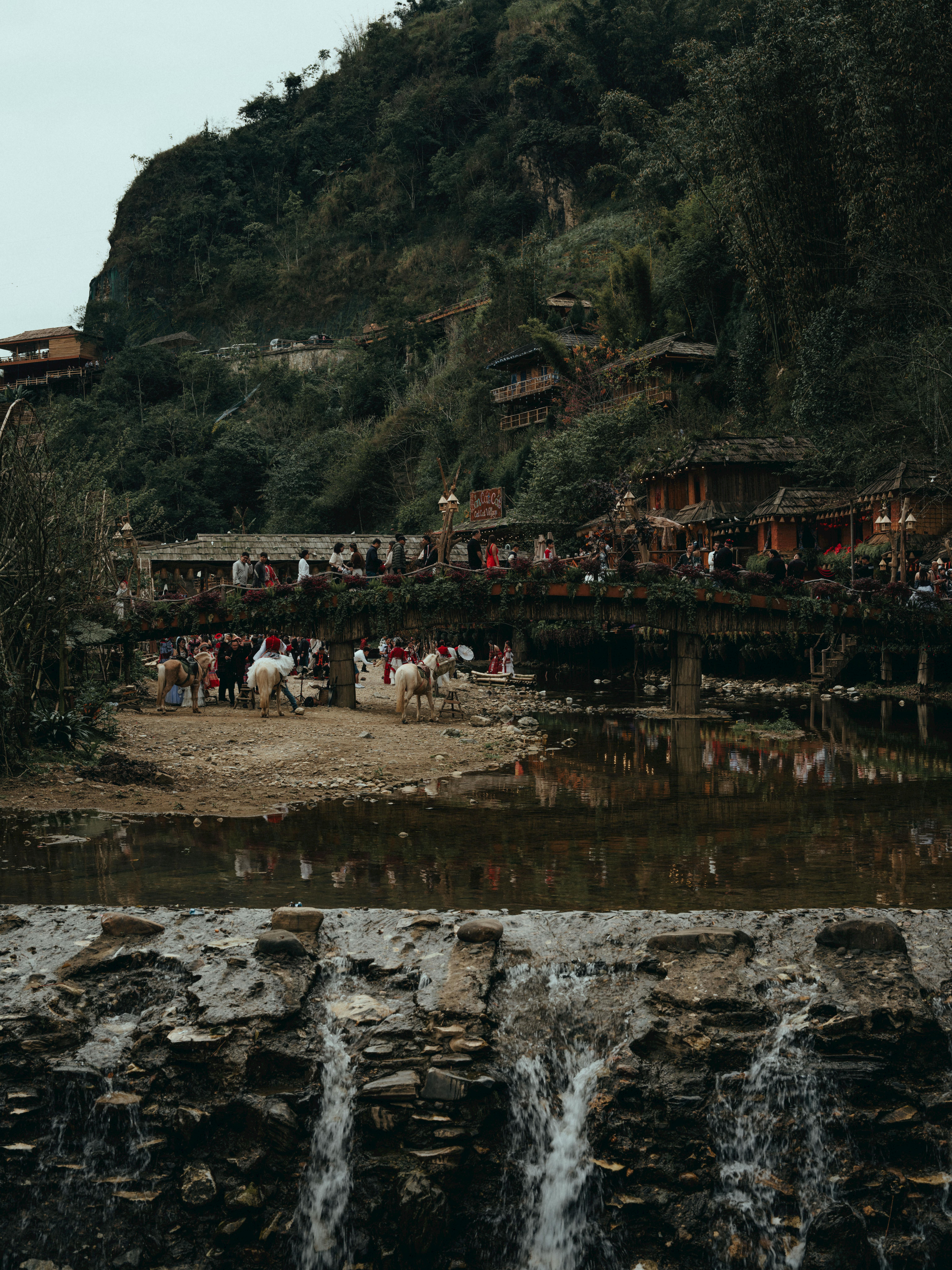 Free A bustling bridge in Lào Cai, Vietnam with people and natural beauty, captured in earthy tones. Stock Photo