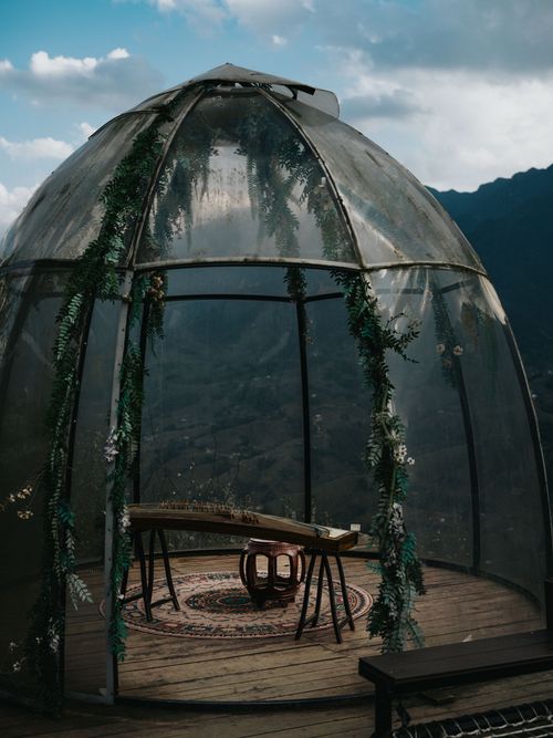 Free A serene setting inside a glass dome with wooden furniture and lush mountain views in Lào Cai, Vietnam. Stock Photo