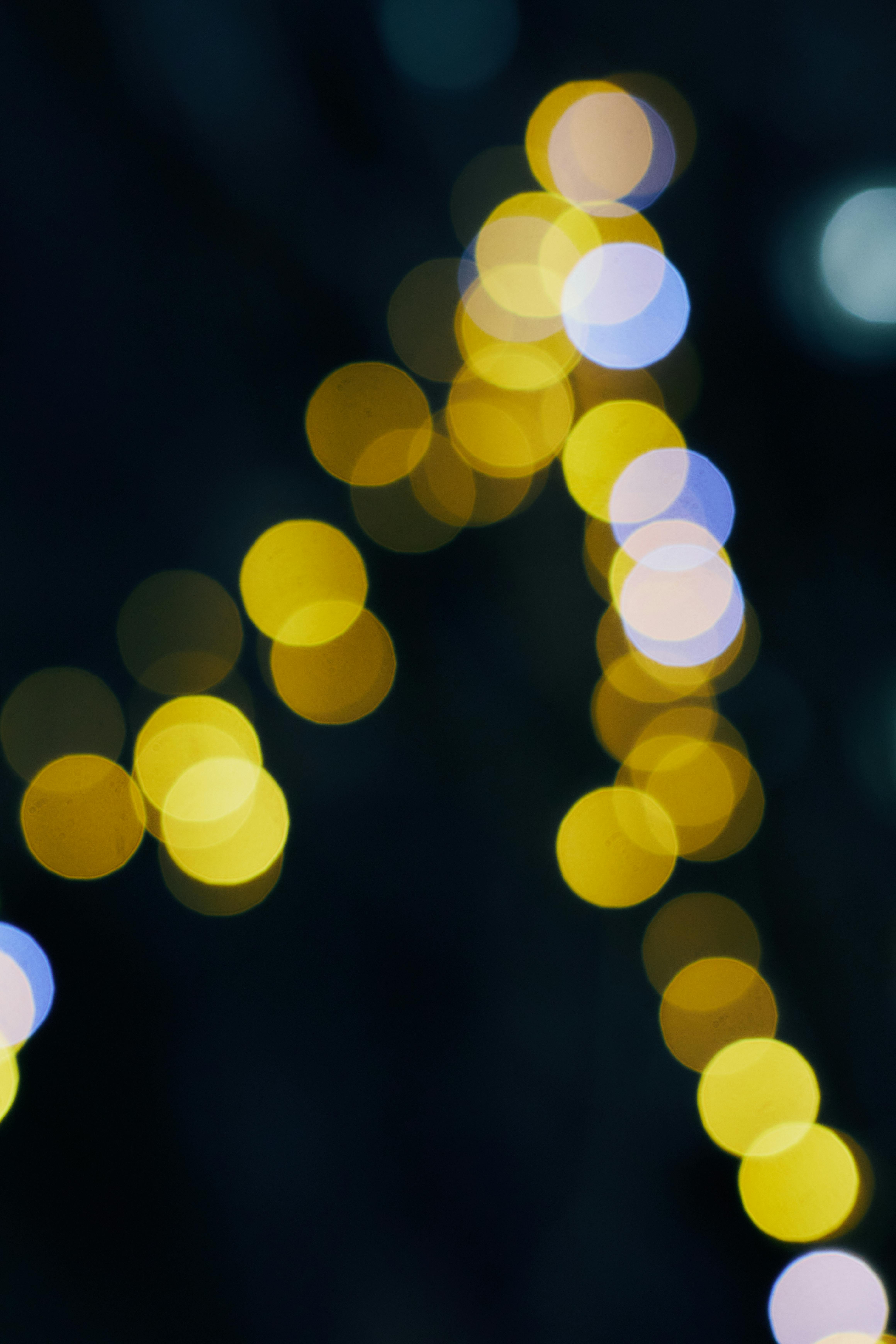 Gratis Et fængslende abstrakt bokeh-lysmønster, der skaber en blød, drømmende atmosfære på en mørk baggrund. Lagerfoto