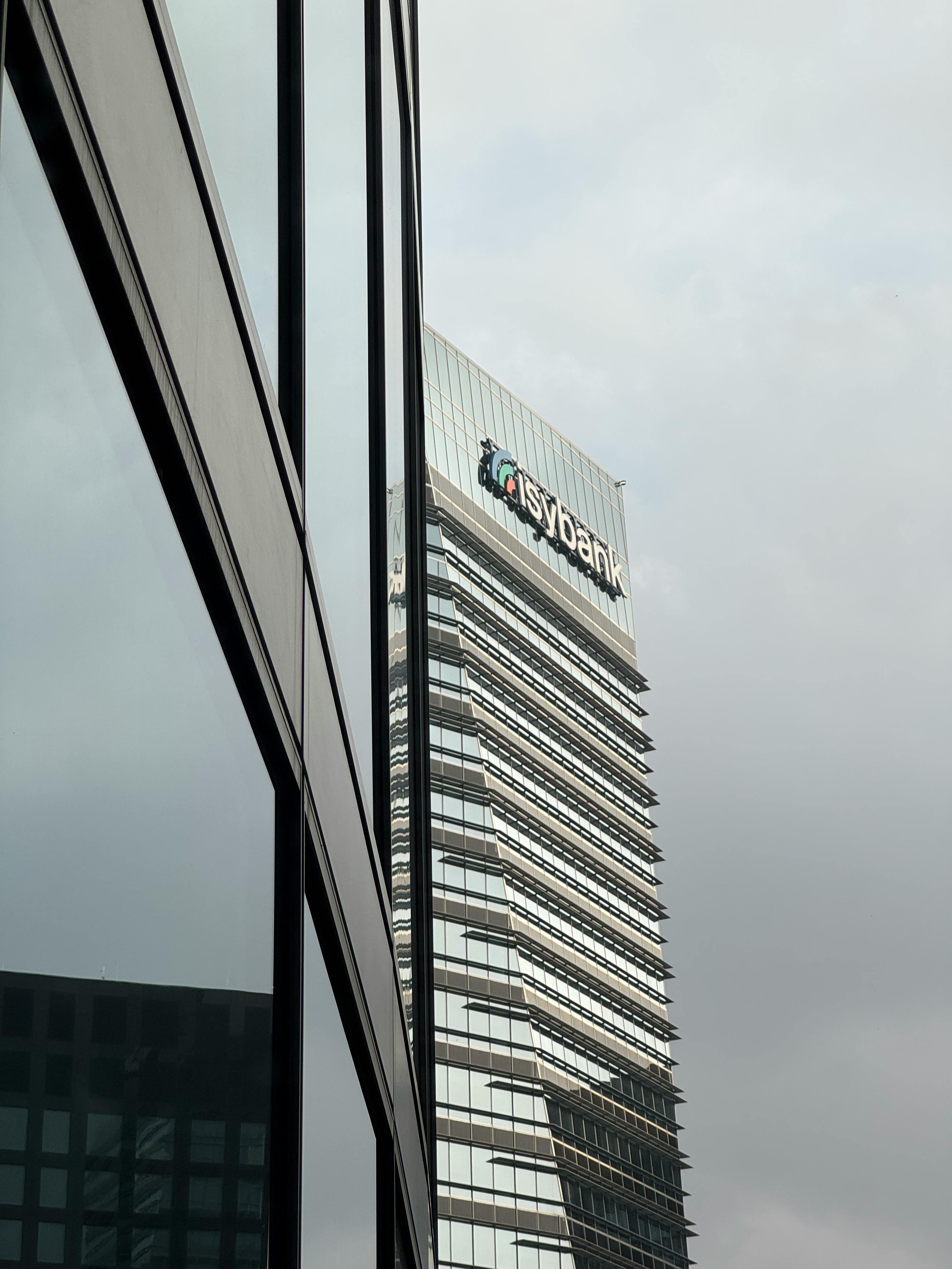 Free A sleek, modern skyscraper against a cloudy sky in Milan's business district. Stock Photo