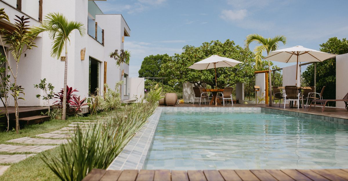 Beautiful modern villa with a pool surrounded by lush greenery in Bahia, Brazil.