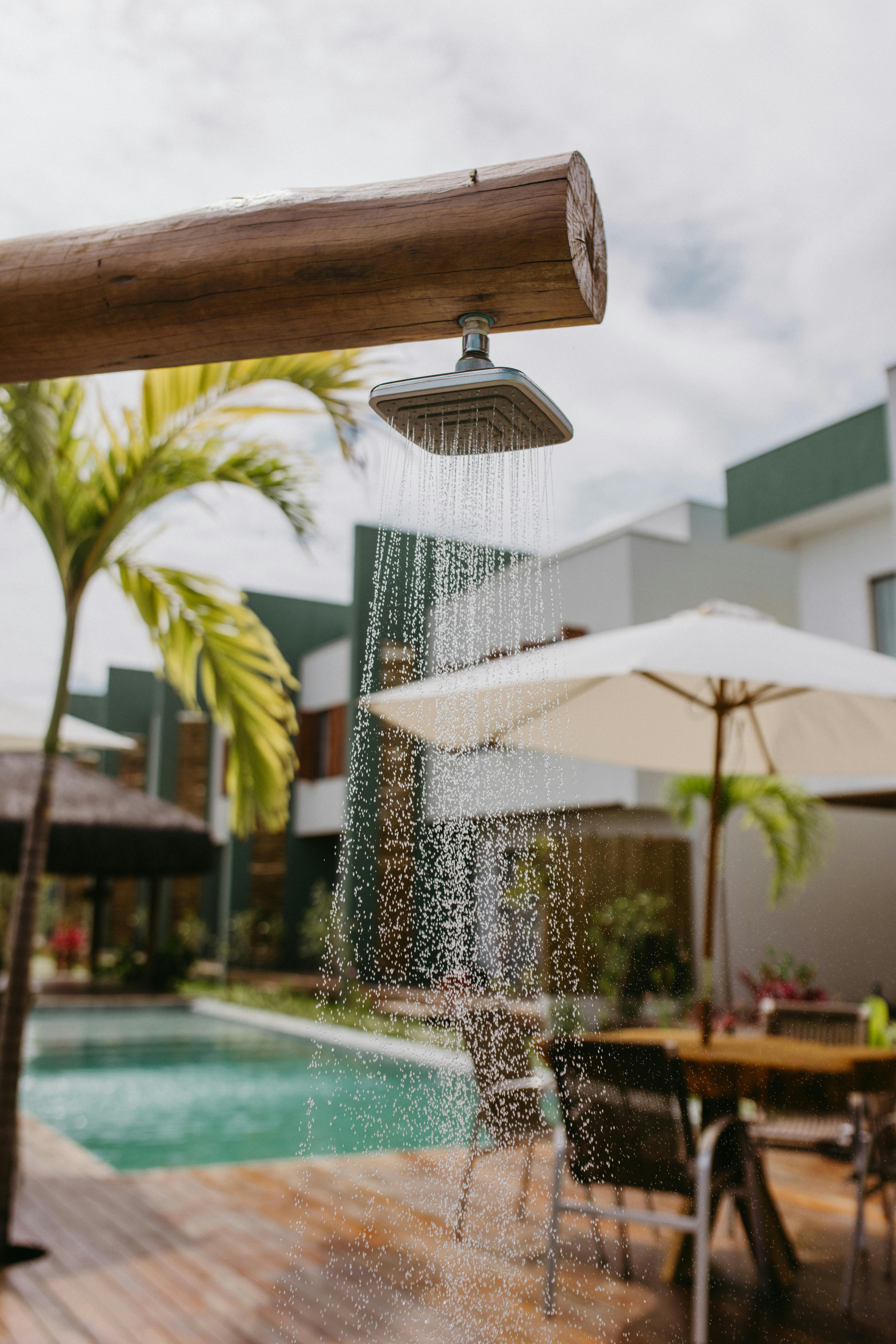 無料 ブラジルのバイーア州にある、屋外シャワーとトロピカルな装飾が施されたリラックスできるプールサイドの風景。 写真素材