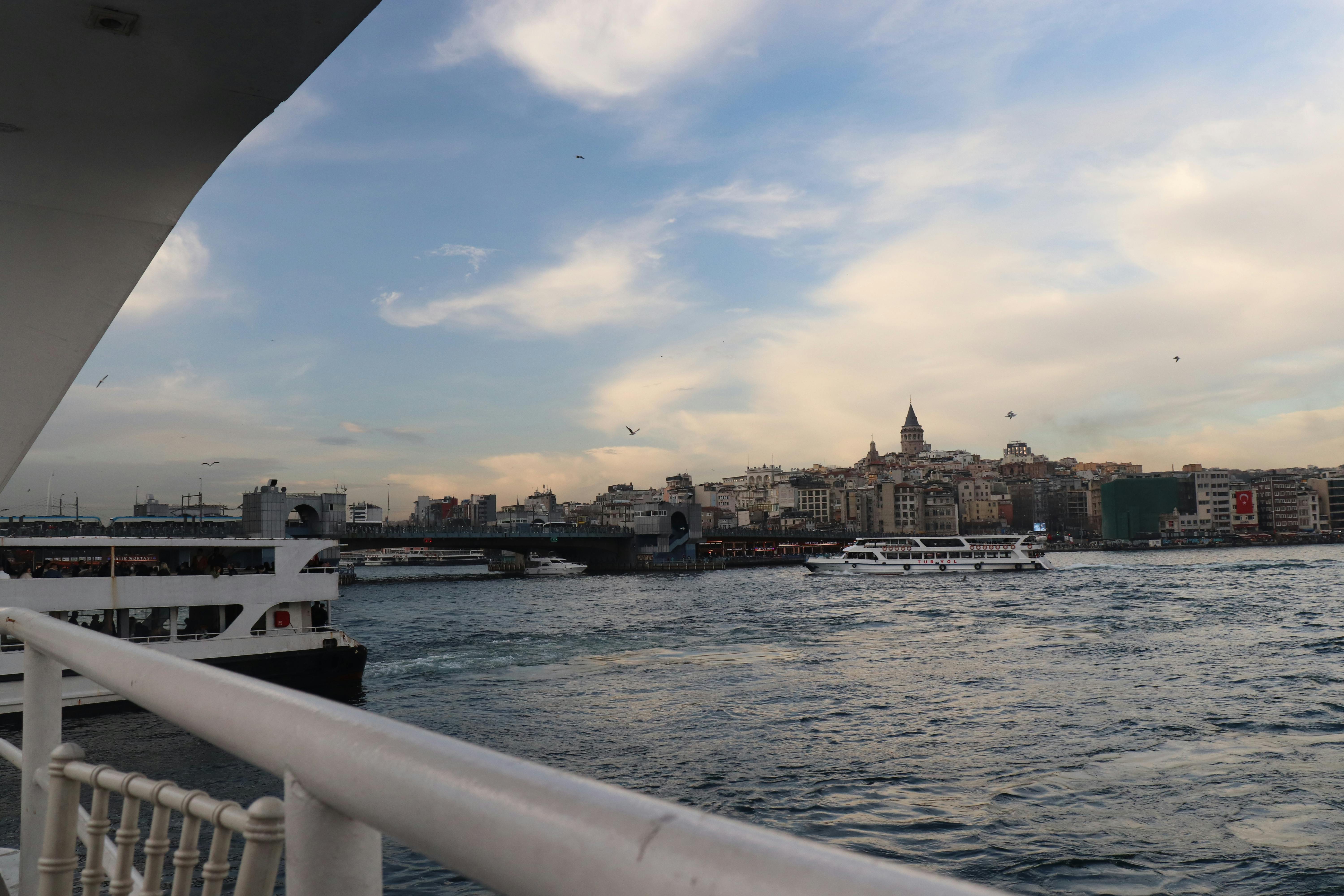 Gratuit Vue imprenable sur la tour de Galata et la ville depuis un ferry sur le Bosphore au coucher du soleil. Photos