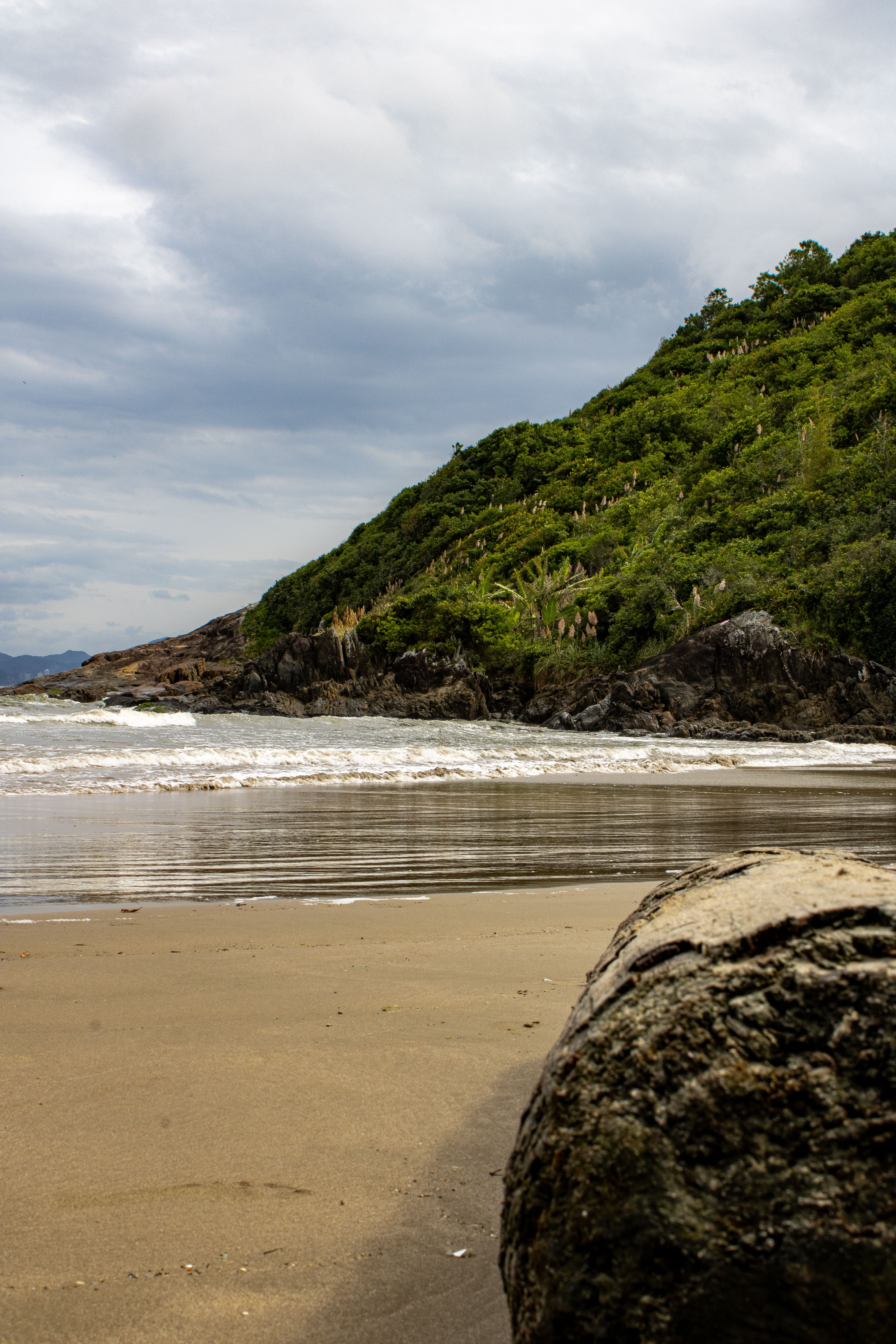 Scenic Beach with Rocky Shoreline and Green Hills · Free Stock Photo