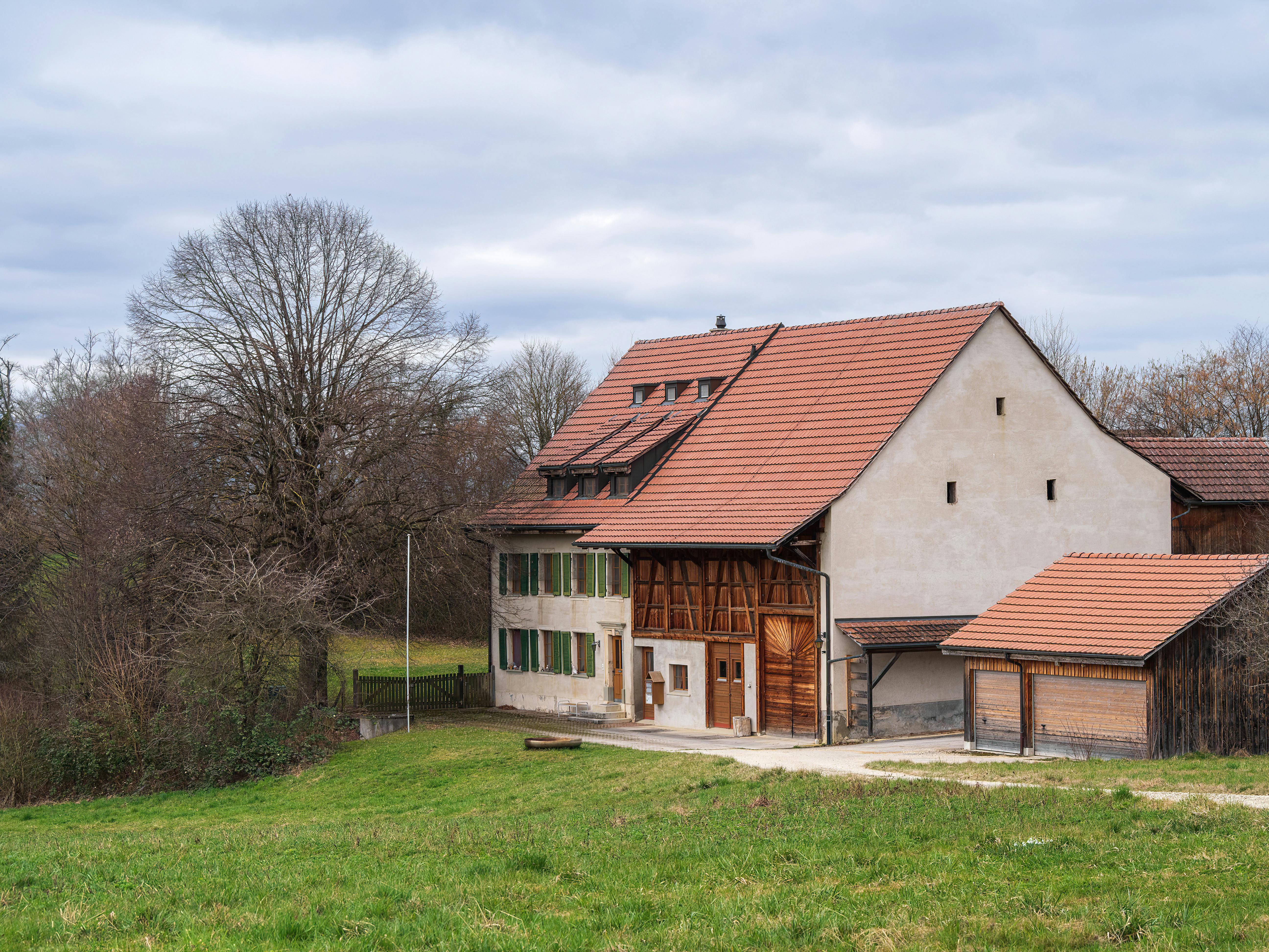 無料 静かな田園地帯にある、赤い屋根の絵のように美しい田舎の家。 写真素材