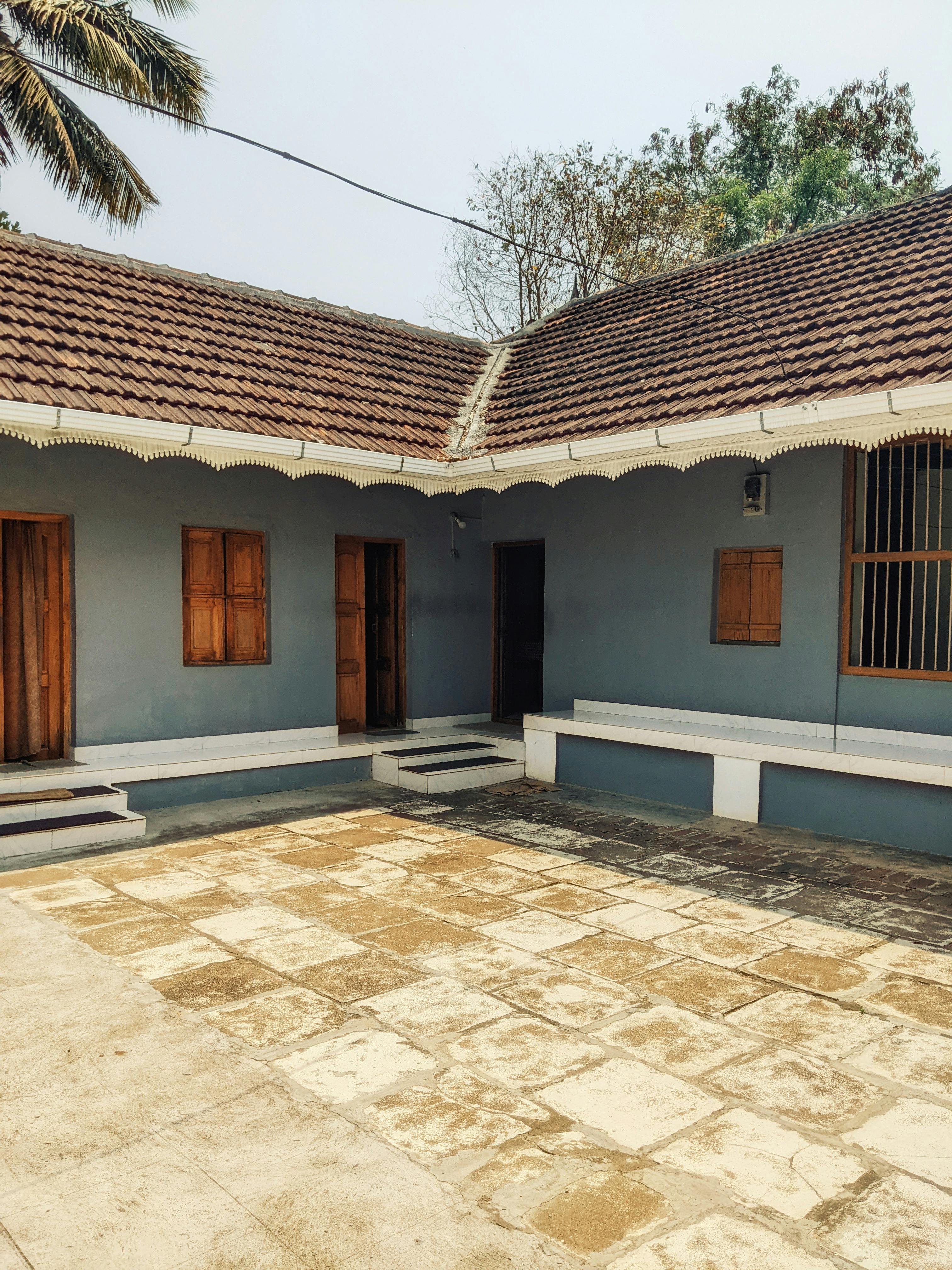 無料 瓦屋根、木製のシャッター、日当たりの良いオープン席を備えた素朴な中庭。 写真素材