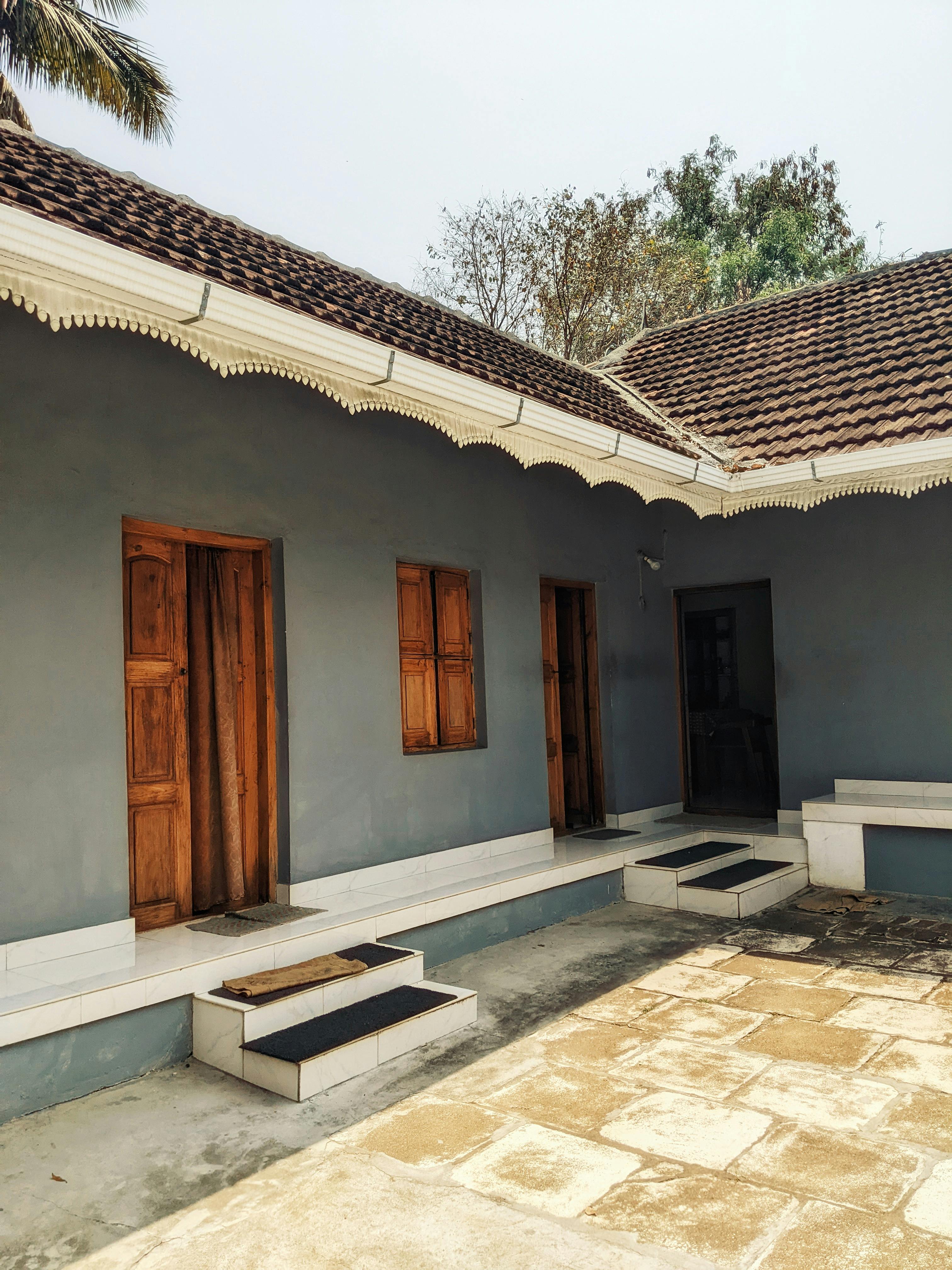 Photograph of a rustic courtyard with traditional architecture and wooden doors.