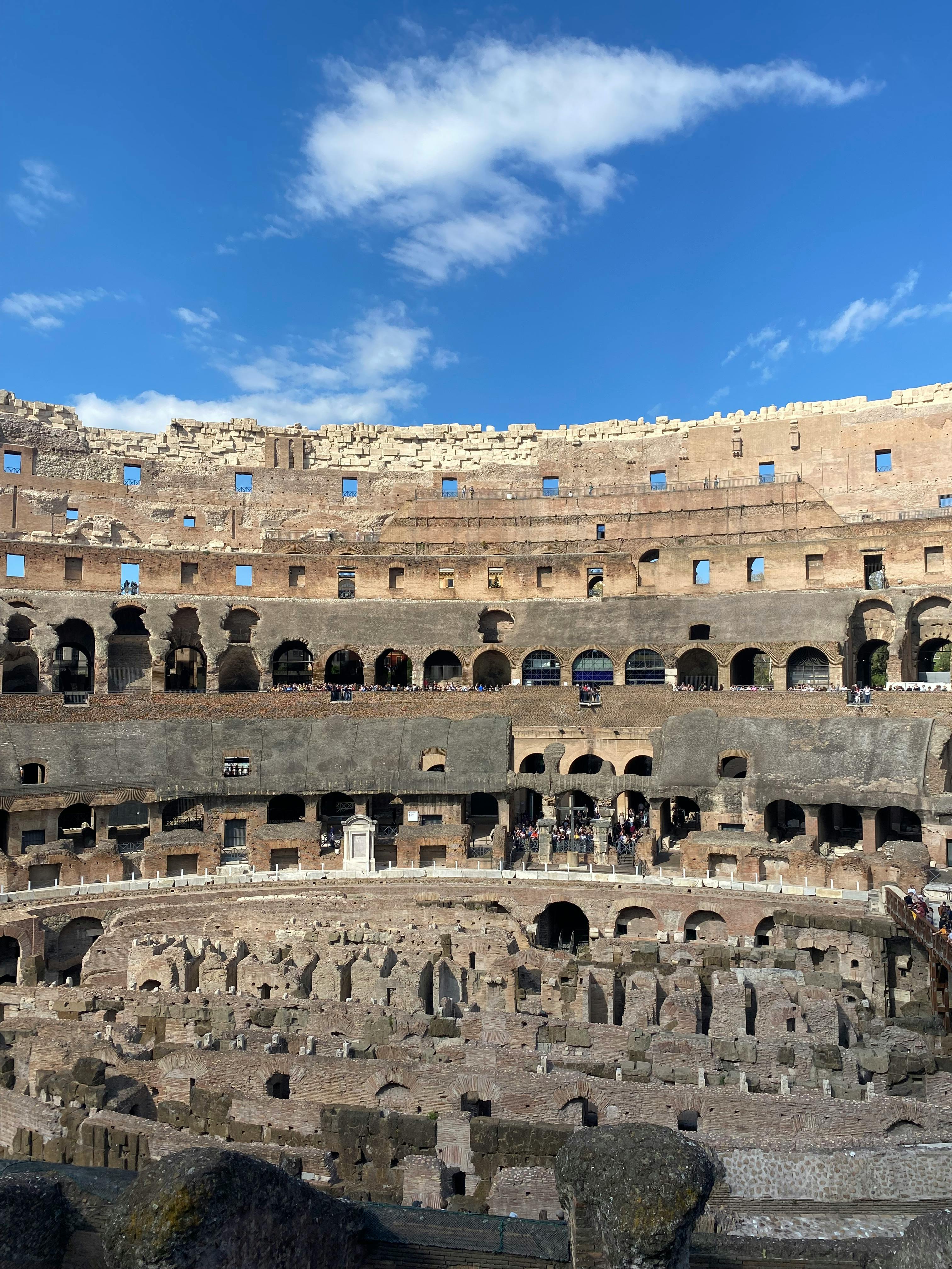 бесплатная Вид на исторический интерьер римского Колизея на фоне чистого голубого неба в Риме, Италия. Стоковое фото