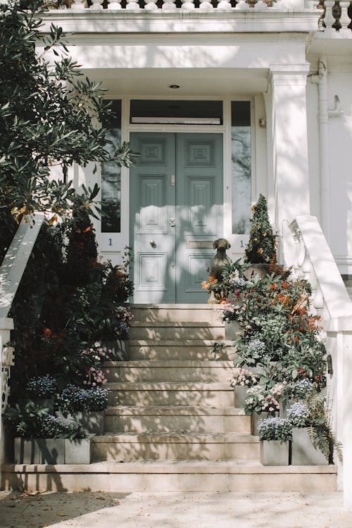 A well-maintained garden with colorful flowers and a painted front door