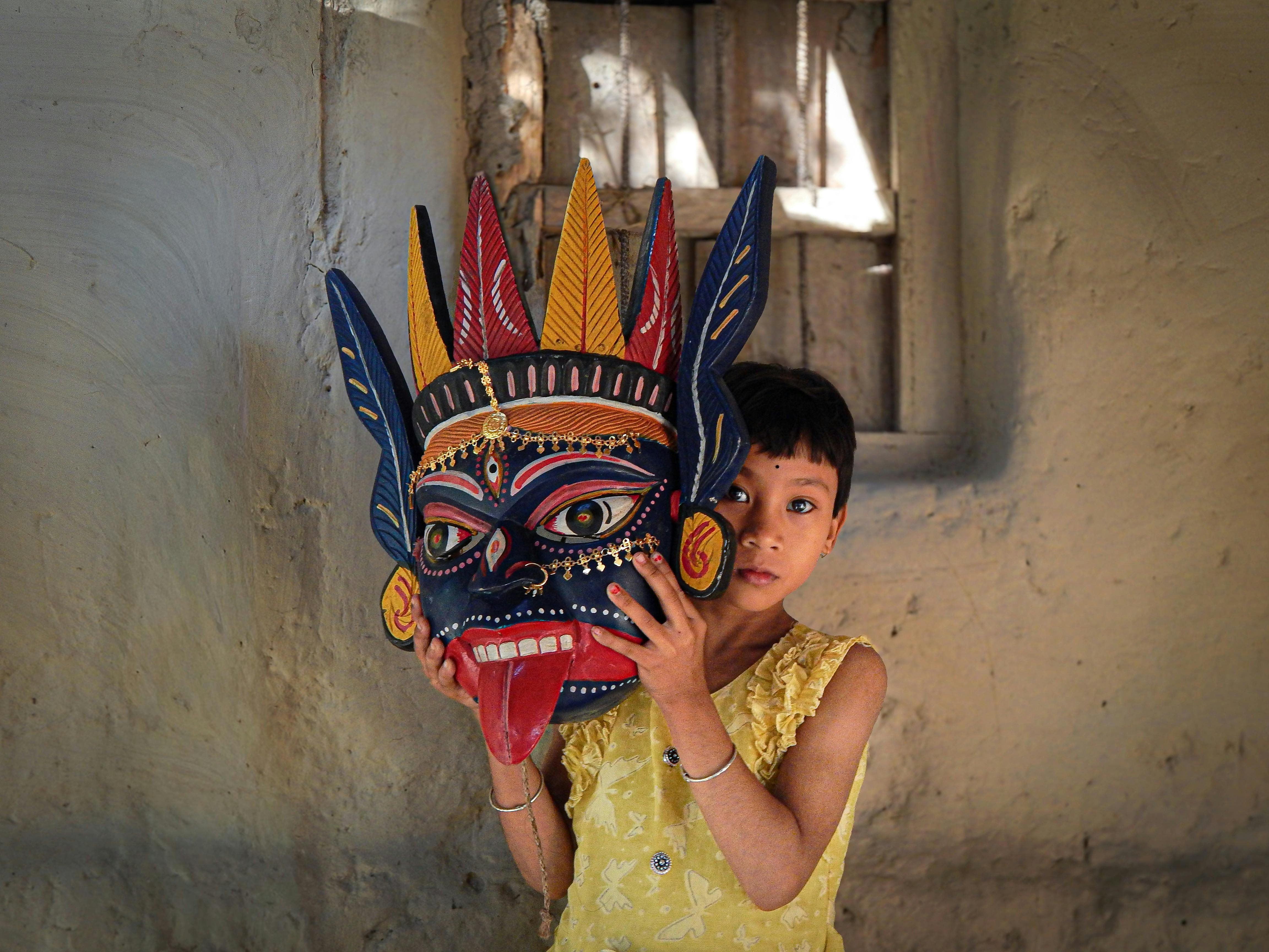 無料 インドでは、子供が伝統的な鮮やかな仮面を持ち、文化遺産を披露しています。 写真素材