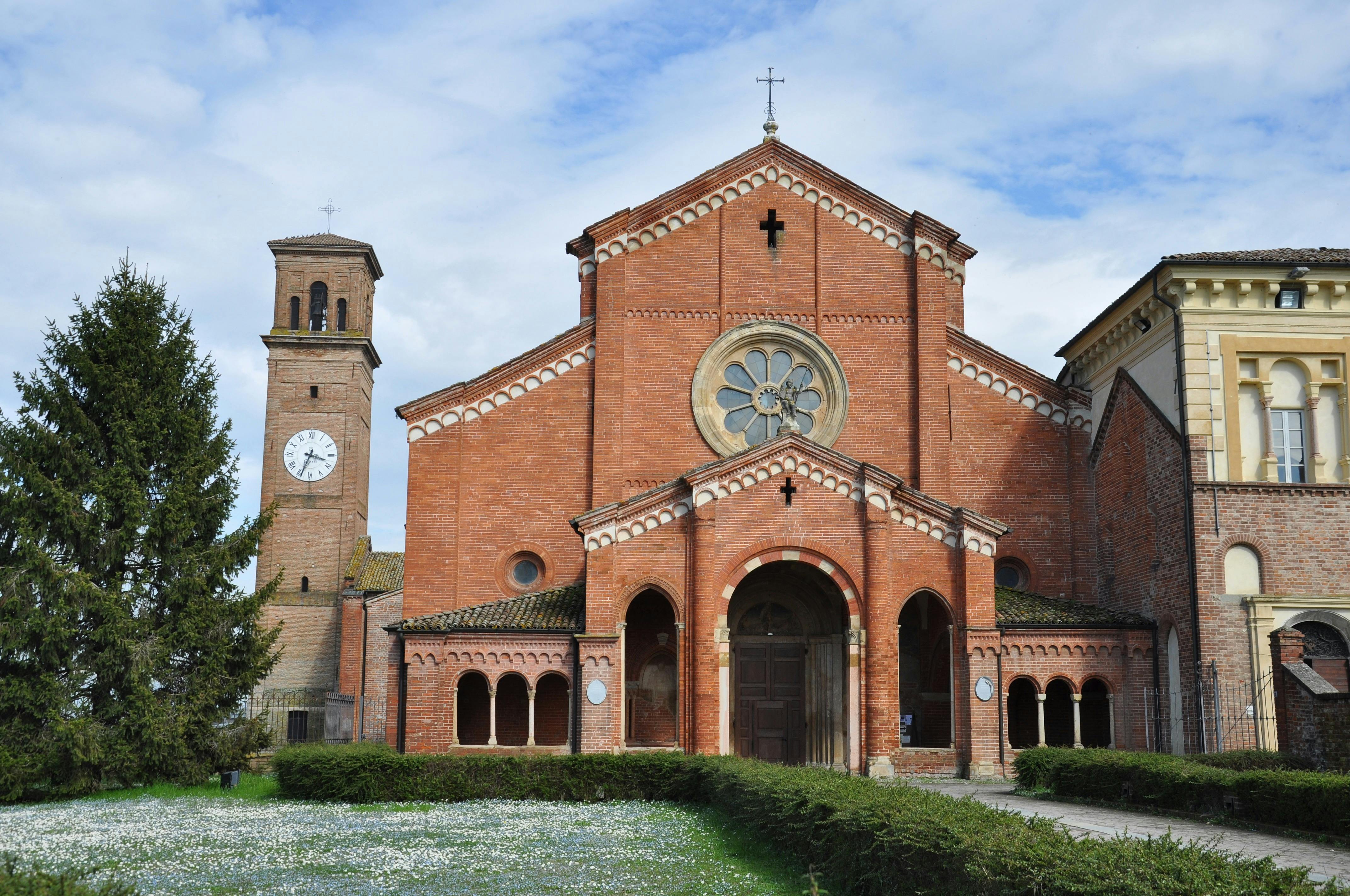 бесплатная Посетите историческое аббатство Кьяравалле в Эмилии-Романье с его классической часовой башней и ярким красным фасадом. Стоковое фото