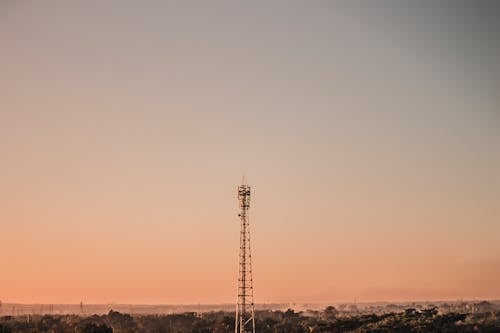 Broadcasting tower under cloudless sundown sky