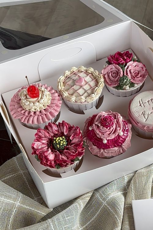 Free A box of intricately decorated floral cupcakes perfect for special occasions. Stock Photo