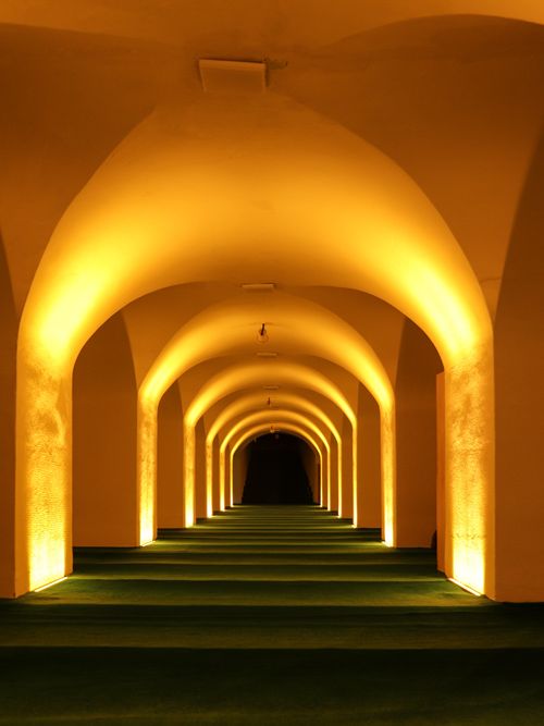 Free A warmly lit tunnel with symmetrical arches creating a dramatic ambiance. Stock Photo