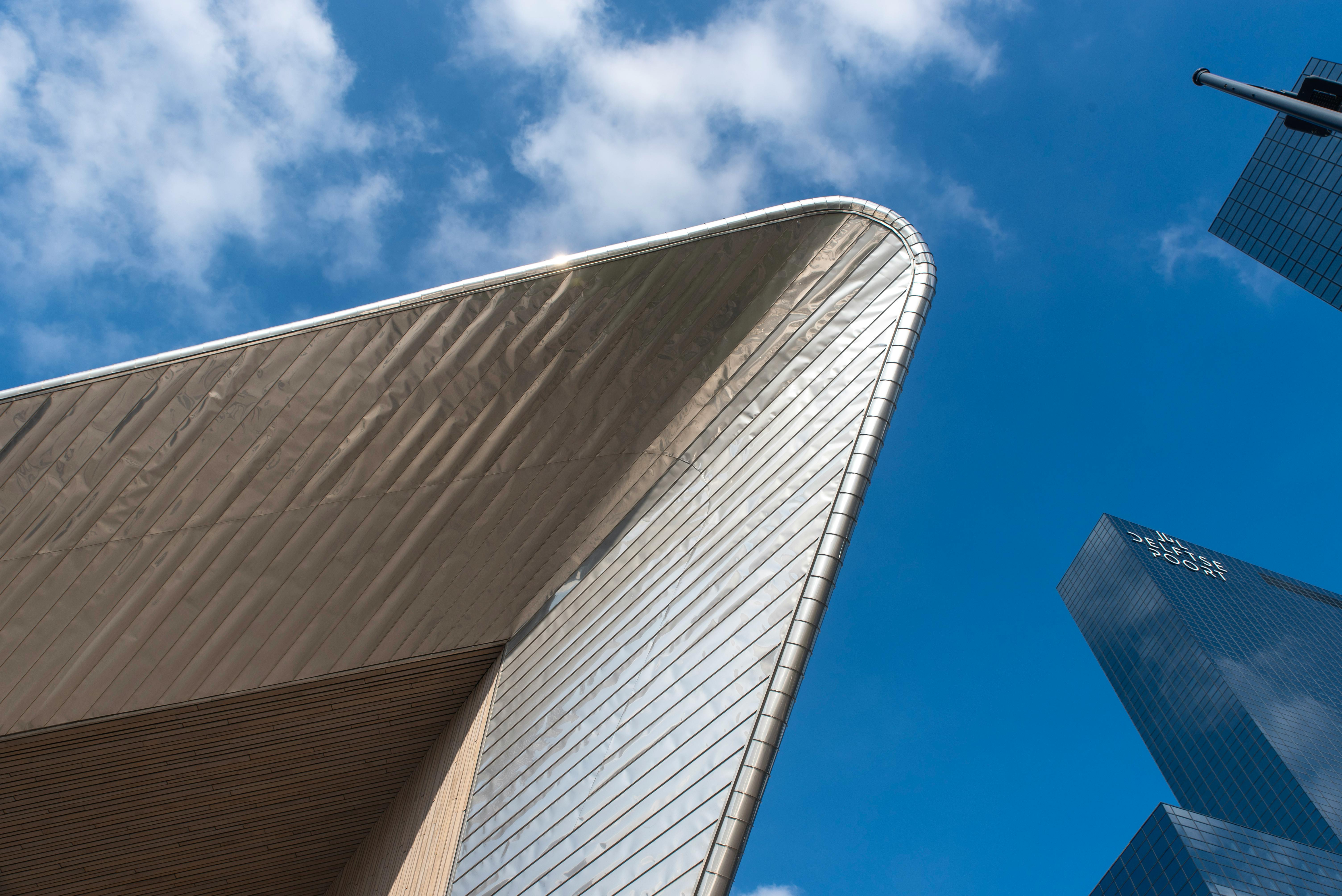 Free Striking modern architecture at Rotterdam Central Station under a clear blue sky. Stock Photo