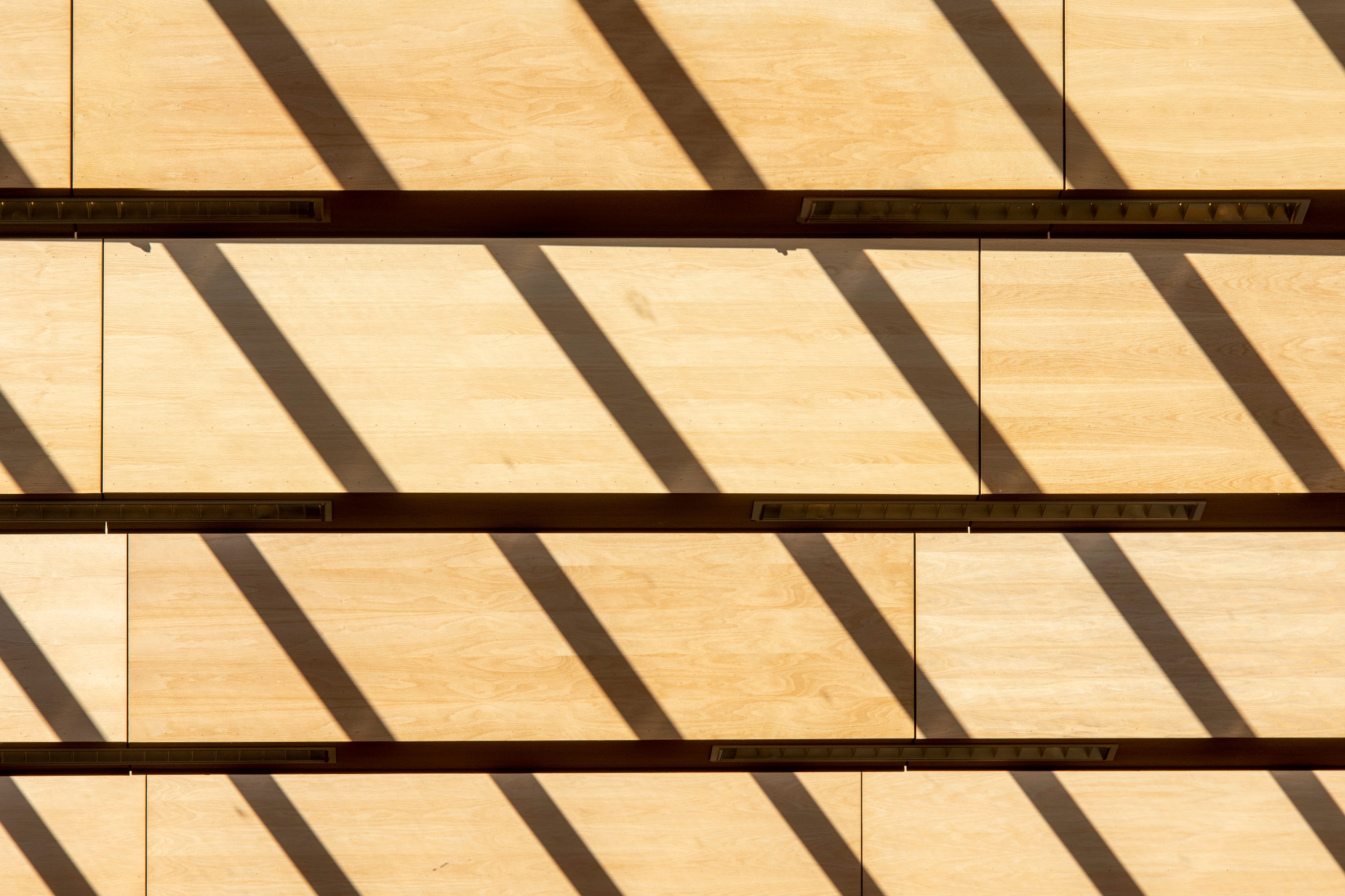 Artistic shadows and patterns on a wooden wall create a unique abstract composition.
