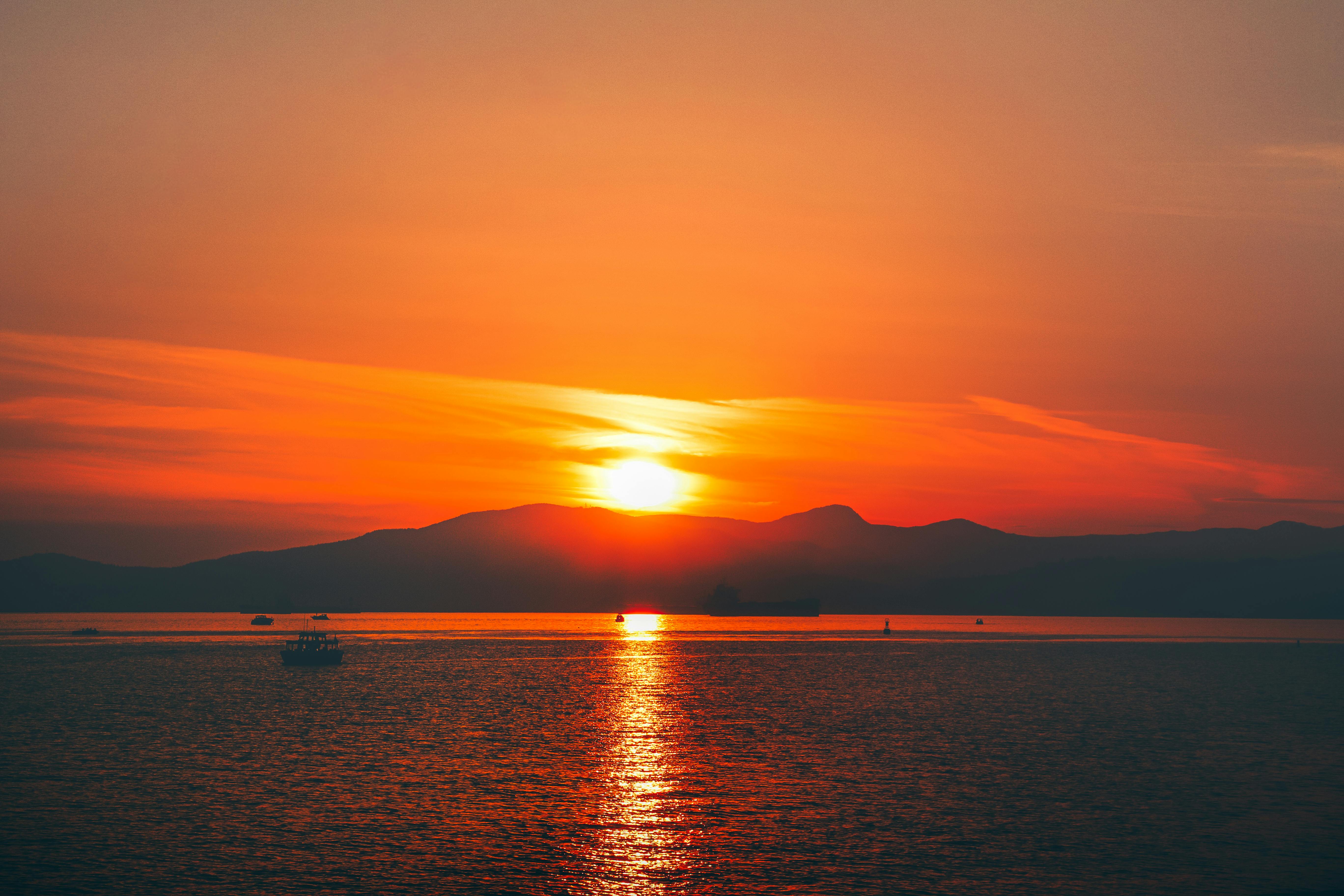 бесплатная Захватывающий дух закат над океаном в Ванкувере, Канада, окрашивающий небо в яркие оранжевые оттенки. Стоковое фото