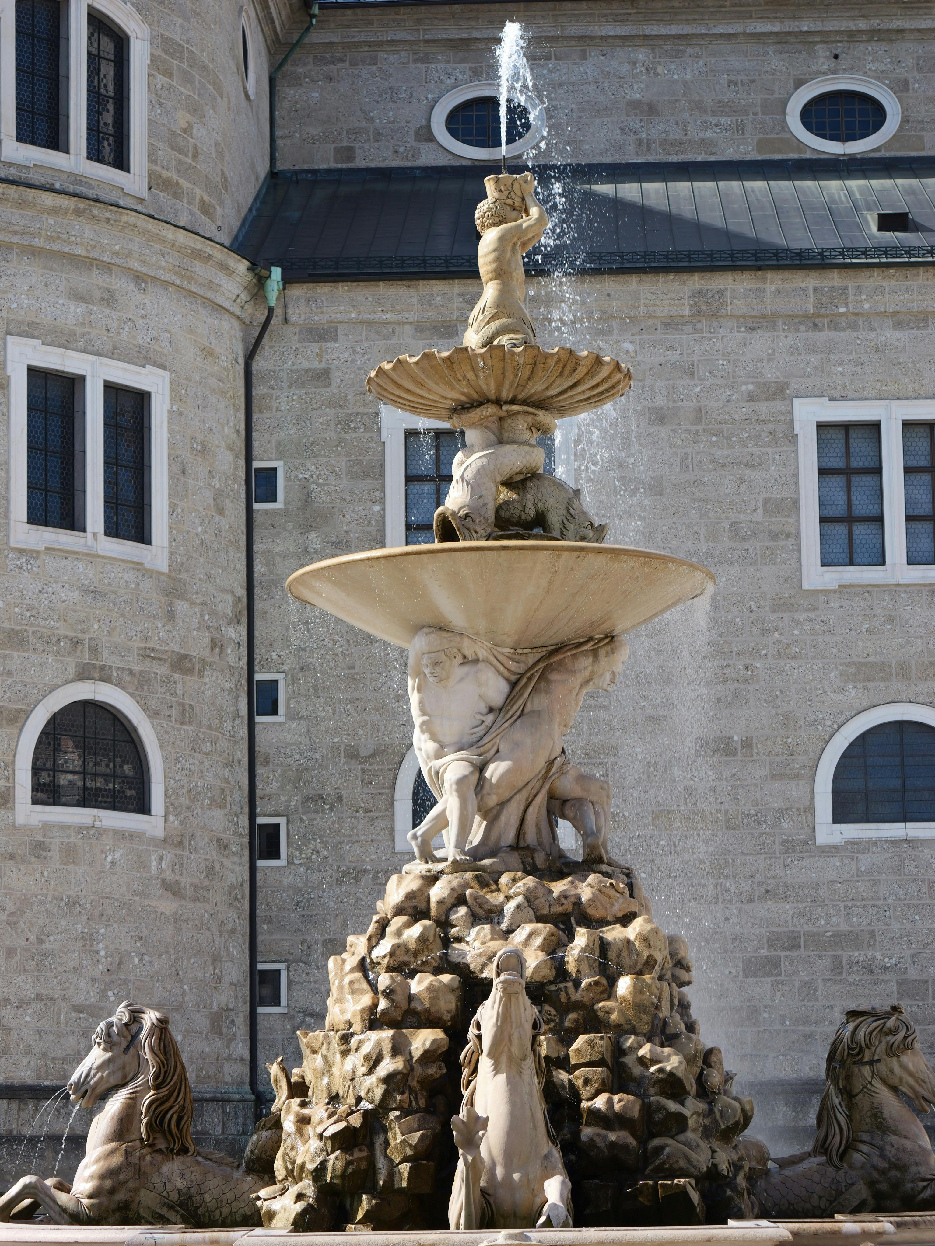 無料 ザルツブルクにある、精巧な石の彫刻と水しぶきが特徴的な、優雅なバロック様式の噴水。 写真素材