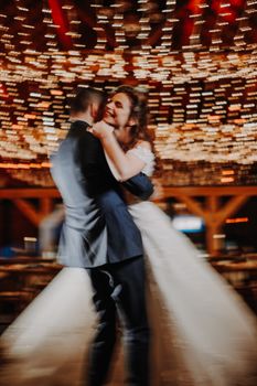 Couple sharing a joyful dance at their wedding reception under soft, twinkling lights in Paris.