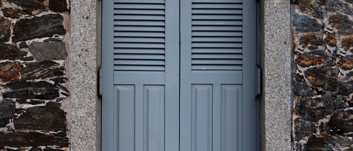 Exterior window shutters being replaced on a home facade