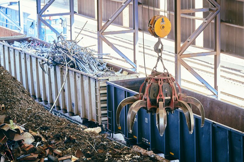 Overhead crane sorting scrap metal in an industrial recycling facility