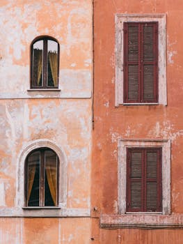 Close-up of rustic Italian architecture in Rome with weathered walls and windows.