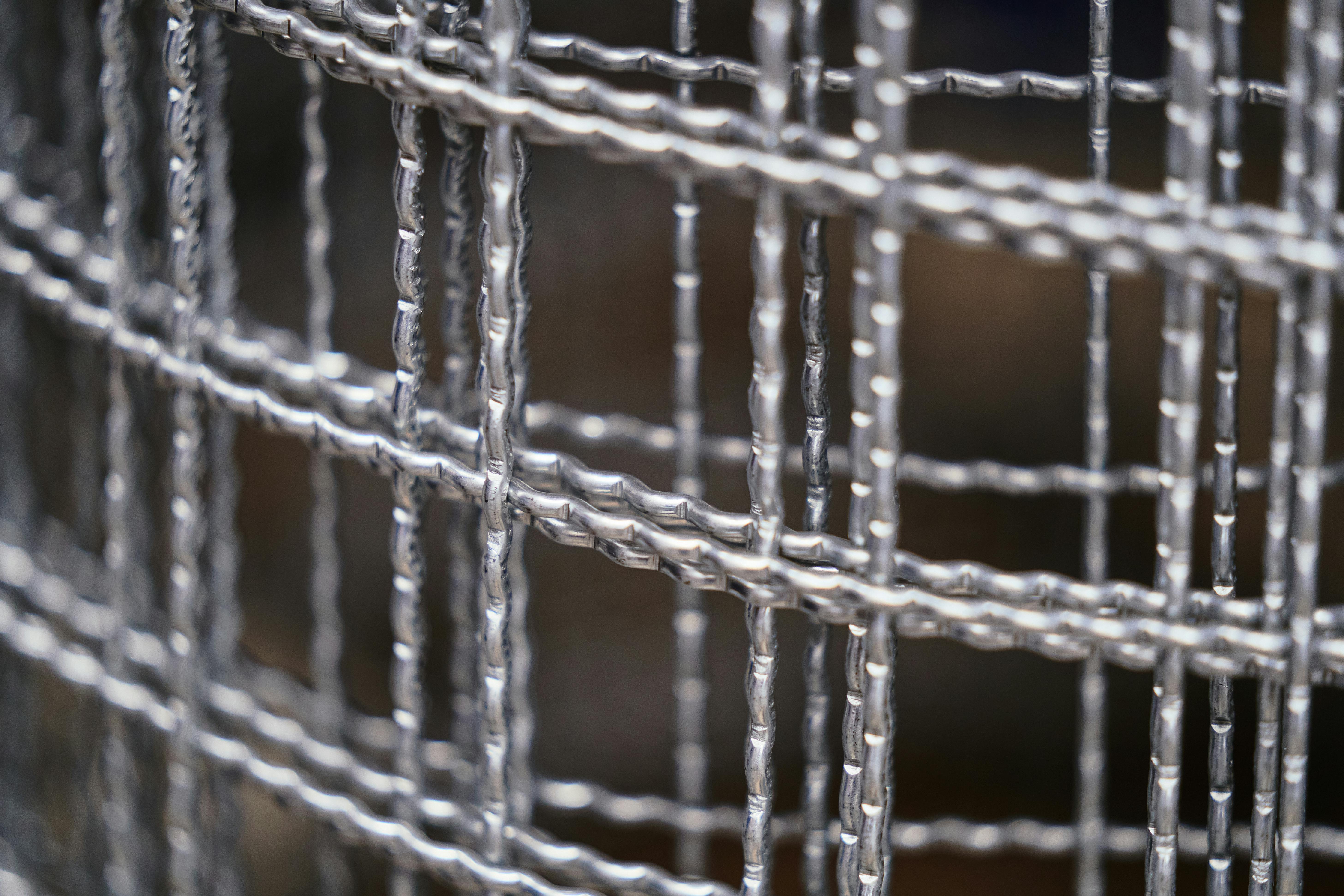 бесплатная Детальный крупный план промышленной проволочной сетки, демонстрирующий текстуру и узоры. Стоковое фото