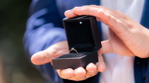 Free Close-up of a man holding a diamond engagement ring in a black box, symbolizing proposal. Stock Photo