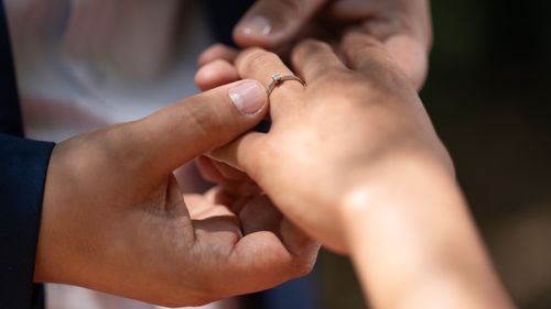 Free Close-up of a romantic wedding proposal with a ring being placed on a finger. Stock Photo